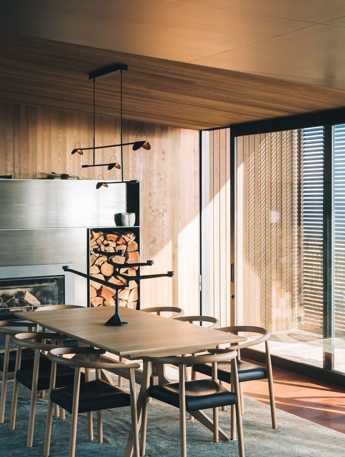 "A custom steel fireplace surround and cabinetry offers a different texture in the otherwise natural palette of the interiors.”