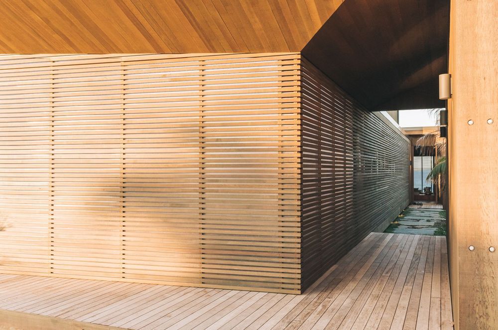 Entrance to the home is by way of a journey along a walkway that moves from decking to pavers to arrive at the front door.