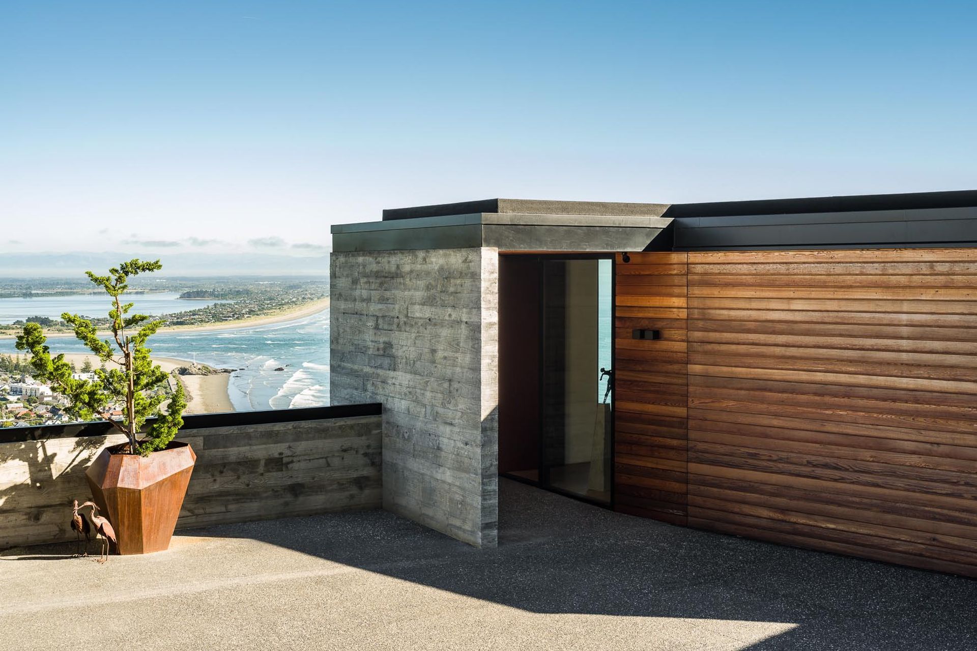 The entry from the road features a humble portal into the home, with a garage and home office located on the home's top level.