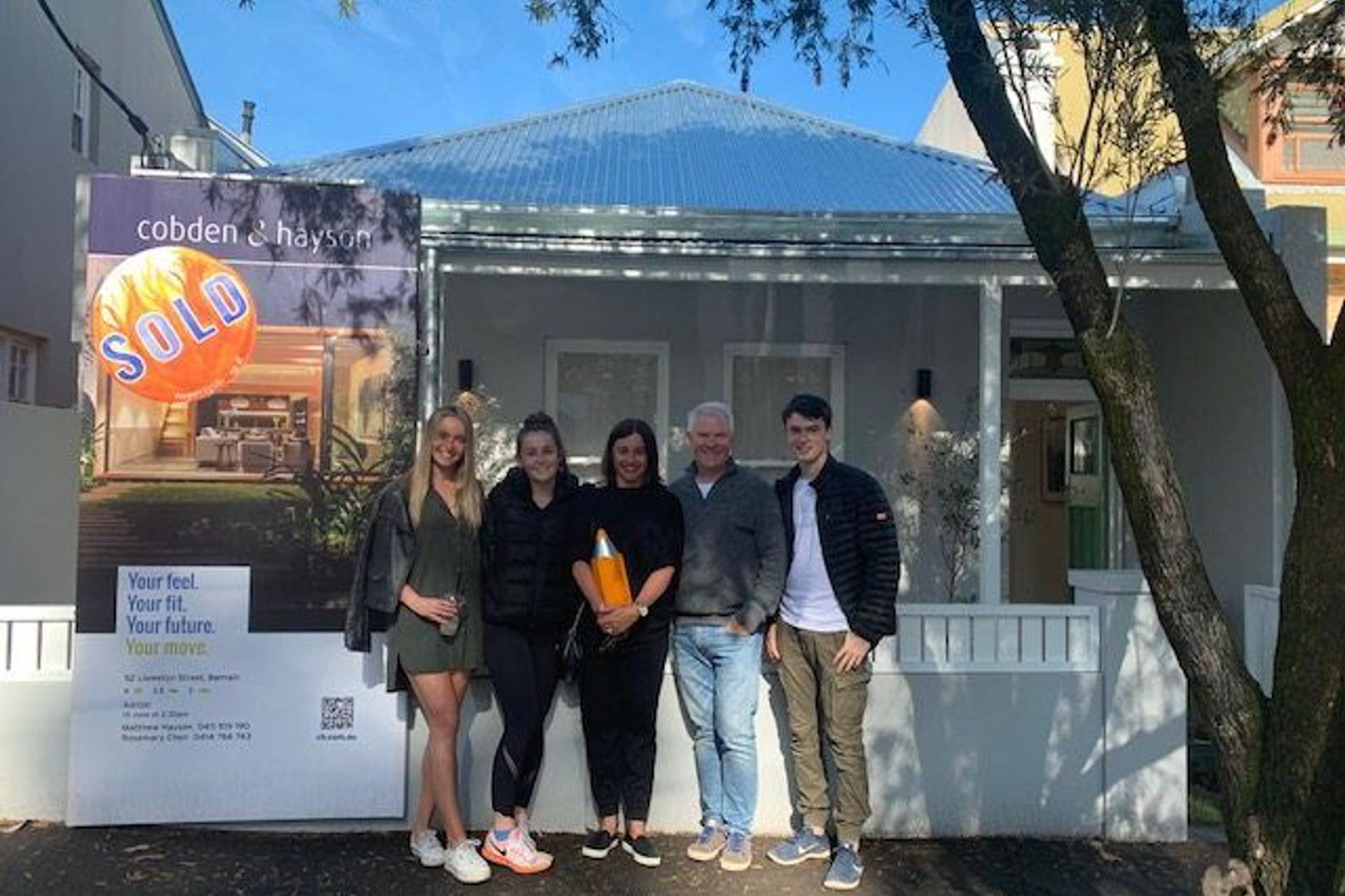 Liza and Mark Evans with their family in front of the house they bought in Balmain