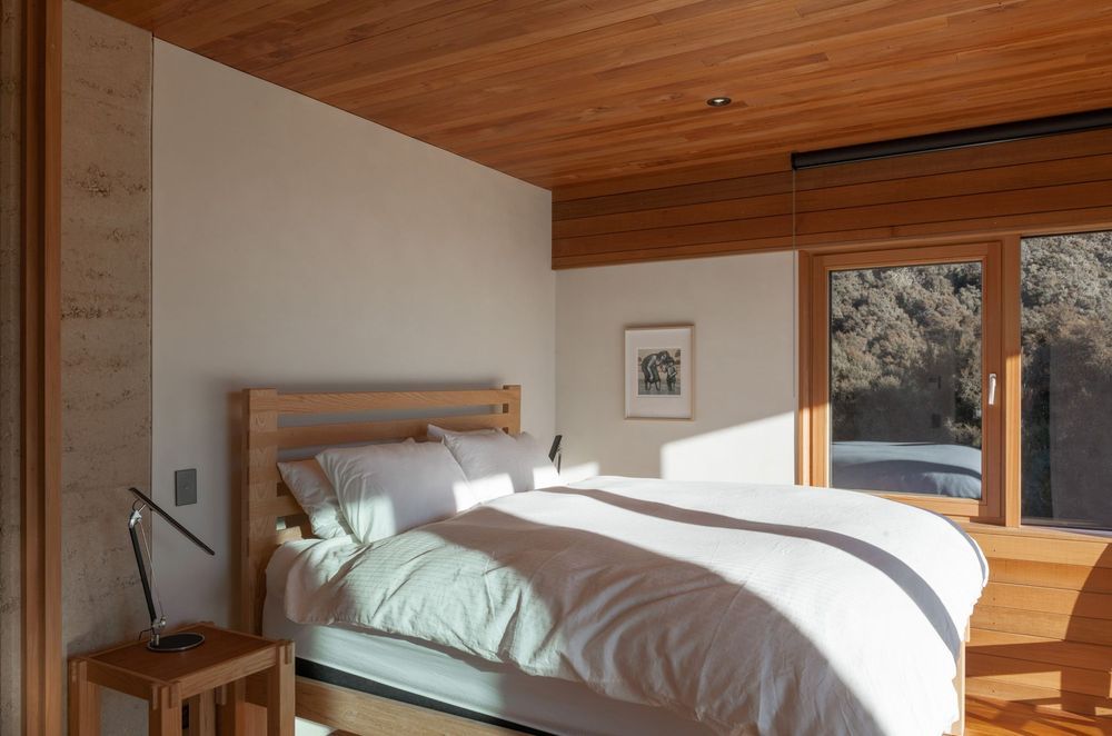 The main bedroom suite is contained within the lower form at the southern-most boundary of the home and like the rest of the home, features a very pared back, natural palette.