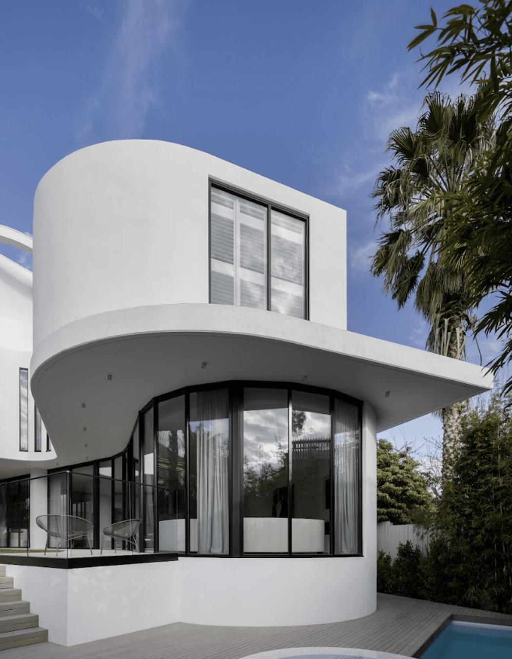 The concrete, formed and moulded into smooth, seamless curves, is coupled with expansive windows that capture light through different times of the day.