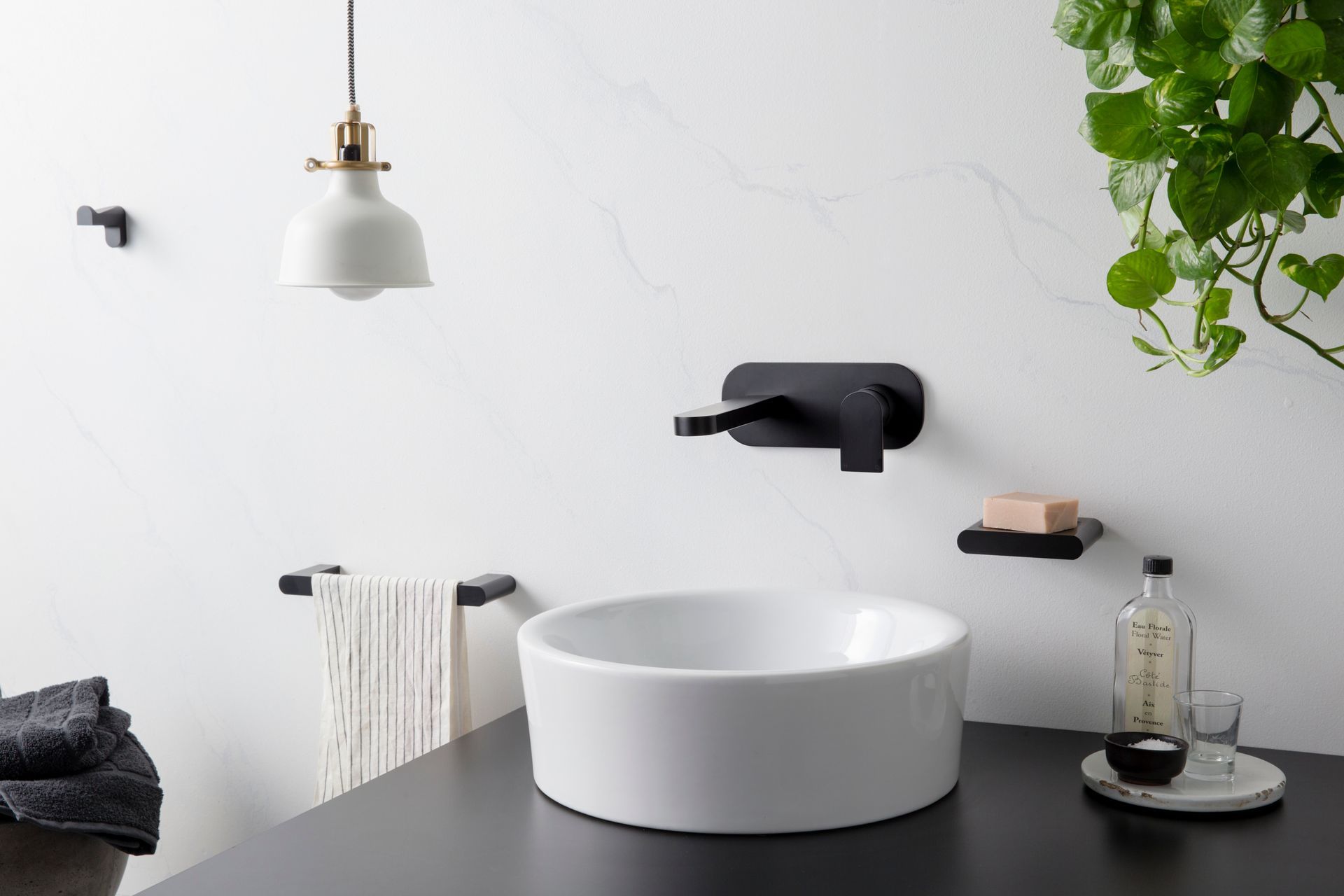 Contemporary bathrooms often feature basins which are placed above the countertop with tapware attached on the wall (Metropolis Black matte tapware from The Kitchen Hub)