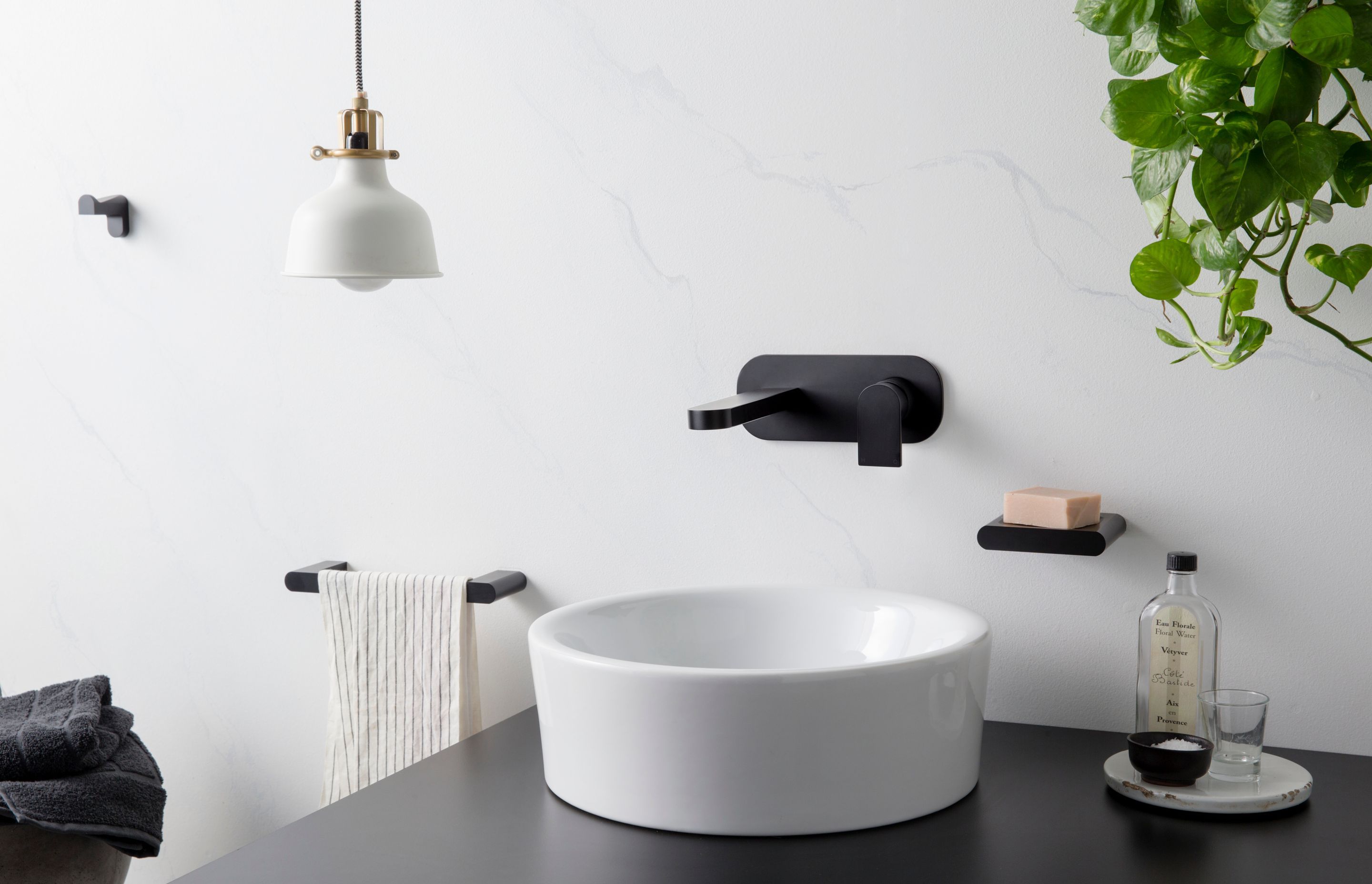 Contemporary bathrooms often feature basins which are placed above the countertop with tapware attached on the wall (Metropolis Black matte tapware from The Kitchen Hub)