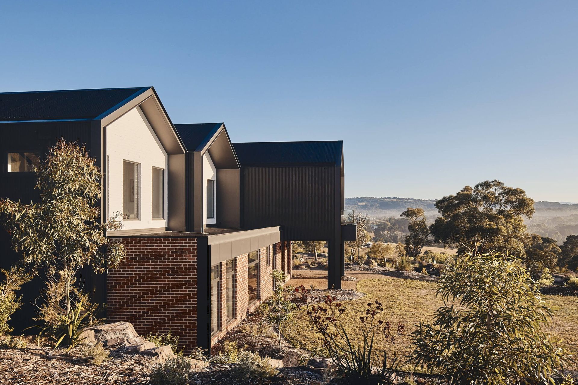 The home is surrounded by lush rolling shills and vegetation. Photography: Peter Bennetts