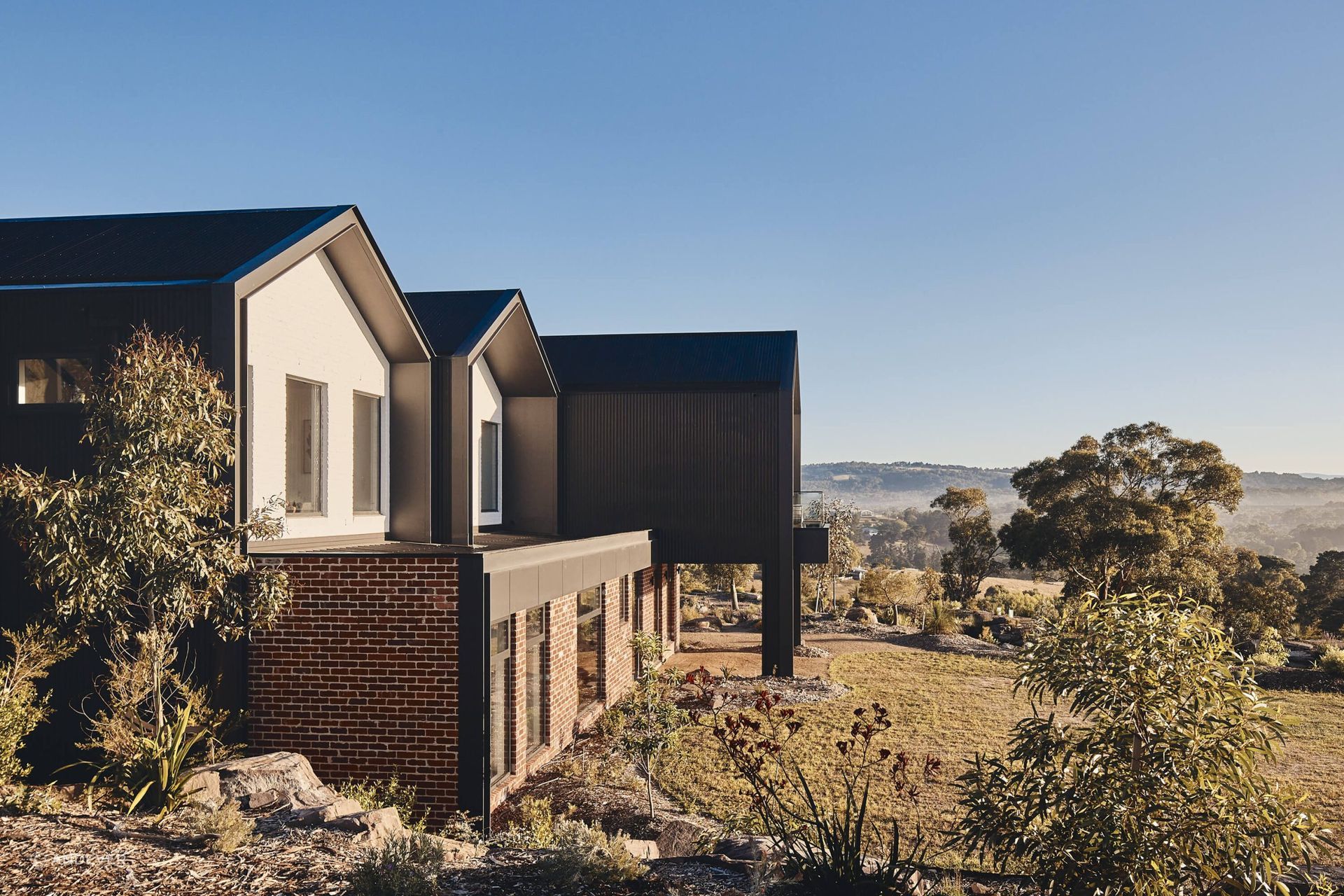 The home is surrounded by lush rolling shills and vegetation. Photography: Peter Bennetts