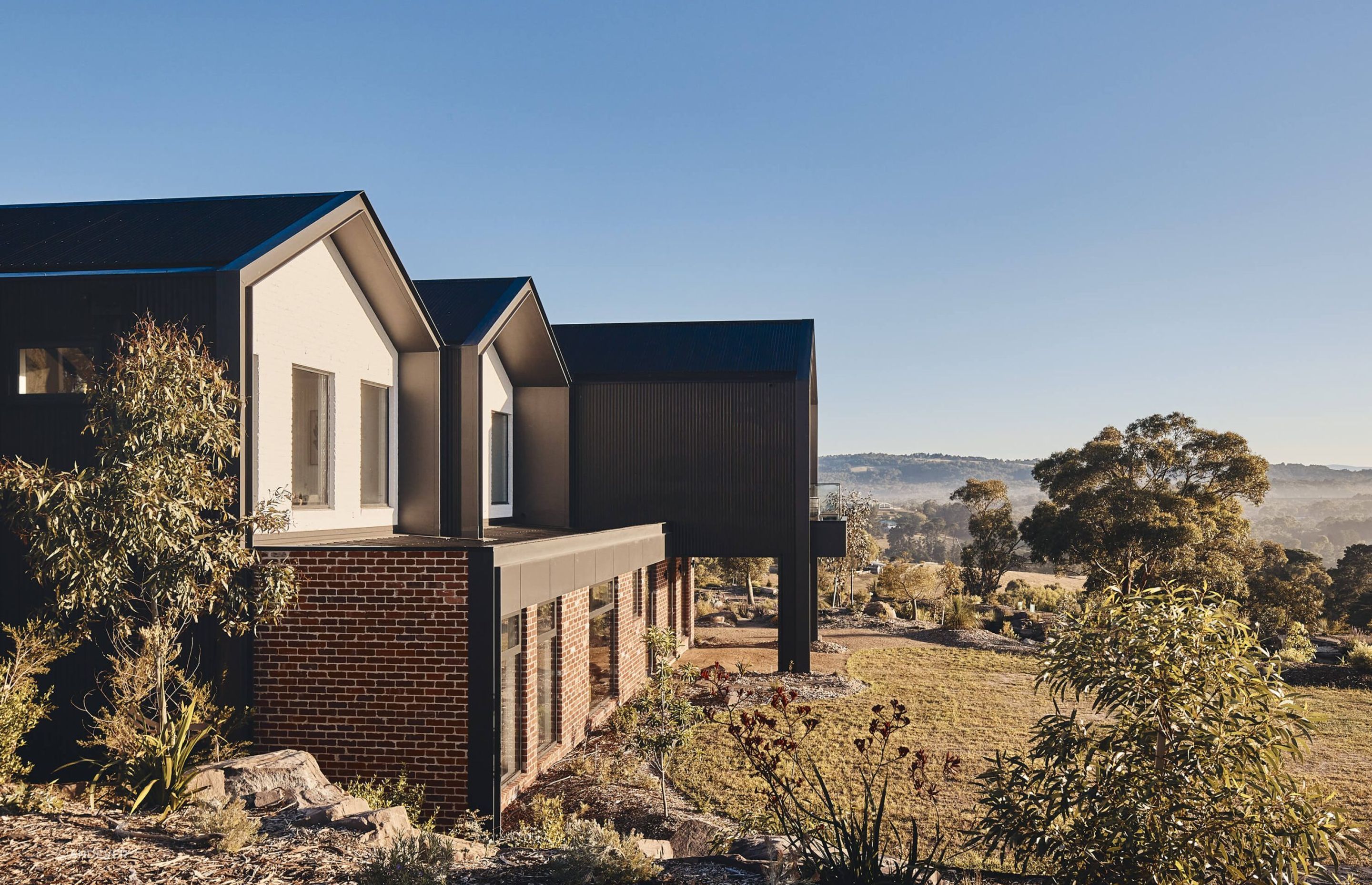 The home is surrounded by lush rolling shills and vegetation. Photography: Peter Bennetts