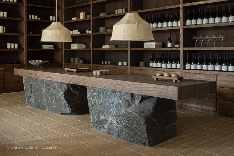 The reception sets the tone with dark timber cabinetry, stone and handcrafted objects. Photography by Jonas Bjerre-Poulsen.