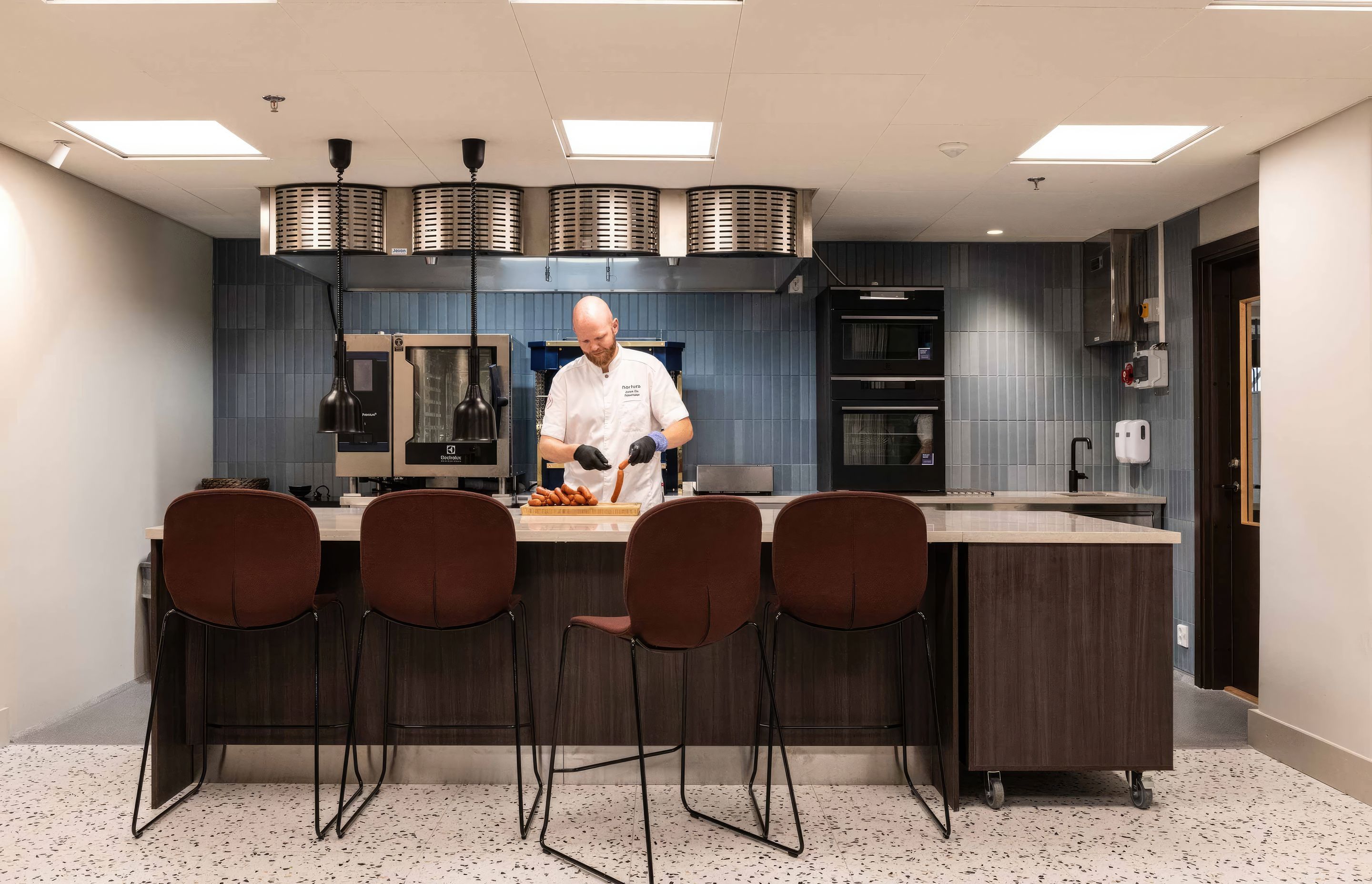 Nortura's show kitchen, previously hidden at the back of the office, was now brought to the heart of the office, signalling its impotance and bringing everyone closer to the food Nortura create. Featured Flokk design: Profim Noor Up in Sirdal (SRD630) fabric by Gudbrandsdalens Uldvarefabrik & Flokk