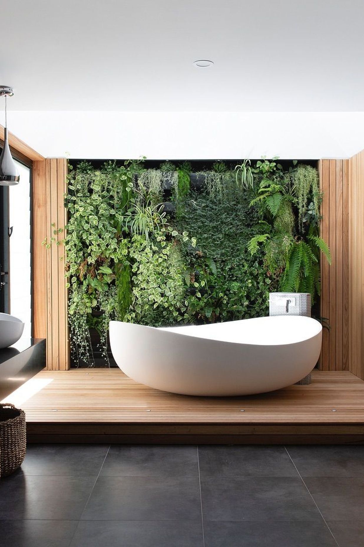 A green wall behind the Onda Bath by BelloCasa.