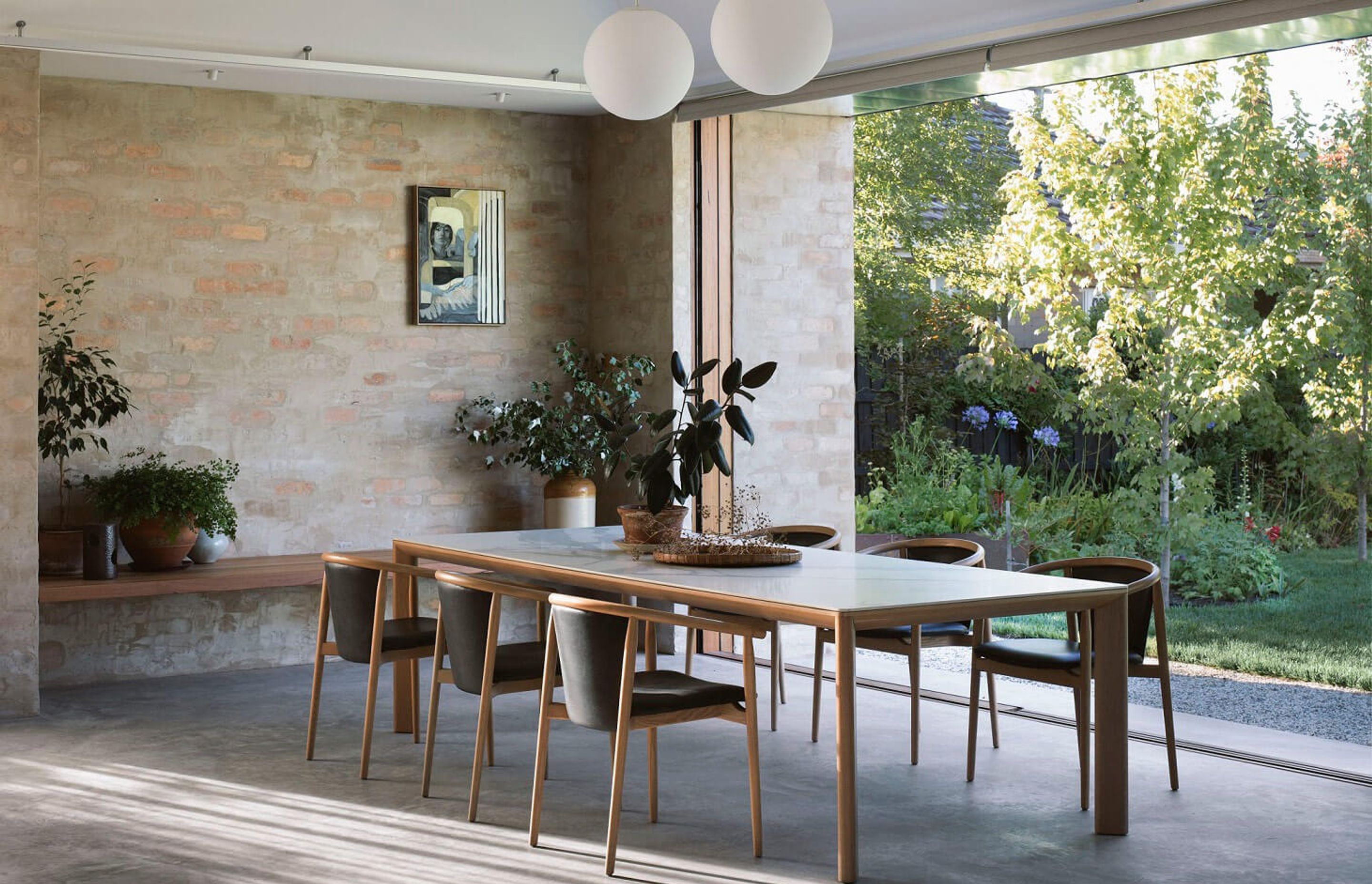The Otway Armchair and Dining Table from the Kett living collection features warm timber tones and minimalist curvaceous forms.
