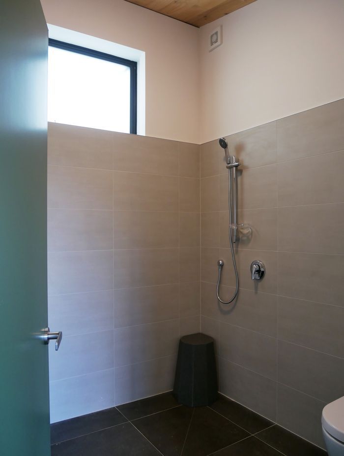 The bathroom is sleek and functional, with a grounded, earthy palette.