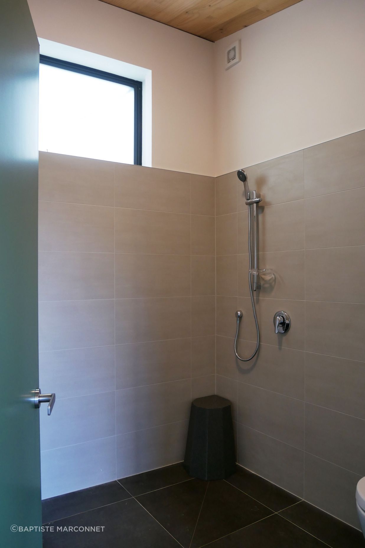 The bathroom is sleek and functional, with a grounded, earthy palette.