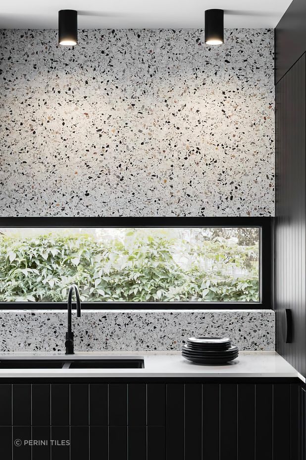 Tiles that feature a bold range of colours or patterns can sometimes feel like a challenge to pair with other materials! A great way to create a sense of cohesion and balance in your colour palette while incorporating pattern tiles is to pick out a single colour from your chosen tile and match this in other areas of your design scheme. This luxurious kitchen for example pairs terrazzo tiles with a black speckled pattern with black kitchen cabinets to create a harmonious look.