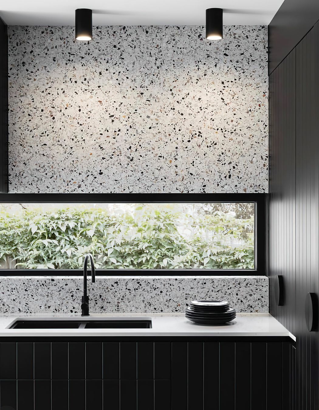 Tiles that feature a bold range of colours or patterns can sometimes feel like a challenge to pair with other materials! A great way to create a sense of cohesion and balance in your colour palette while incorporating pattern tiles is to pick out a single colour from your chosen tile and match this in other areas of your design scheme. This luxurious kitchen for example pairs terrazzo tiles with a black speckled pattern with black kitchen cabinets to create a harmonious look.