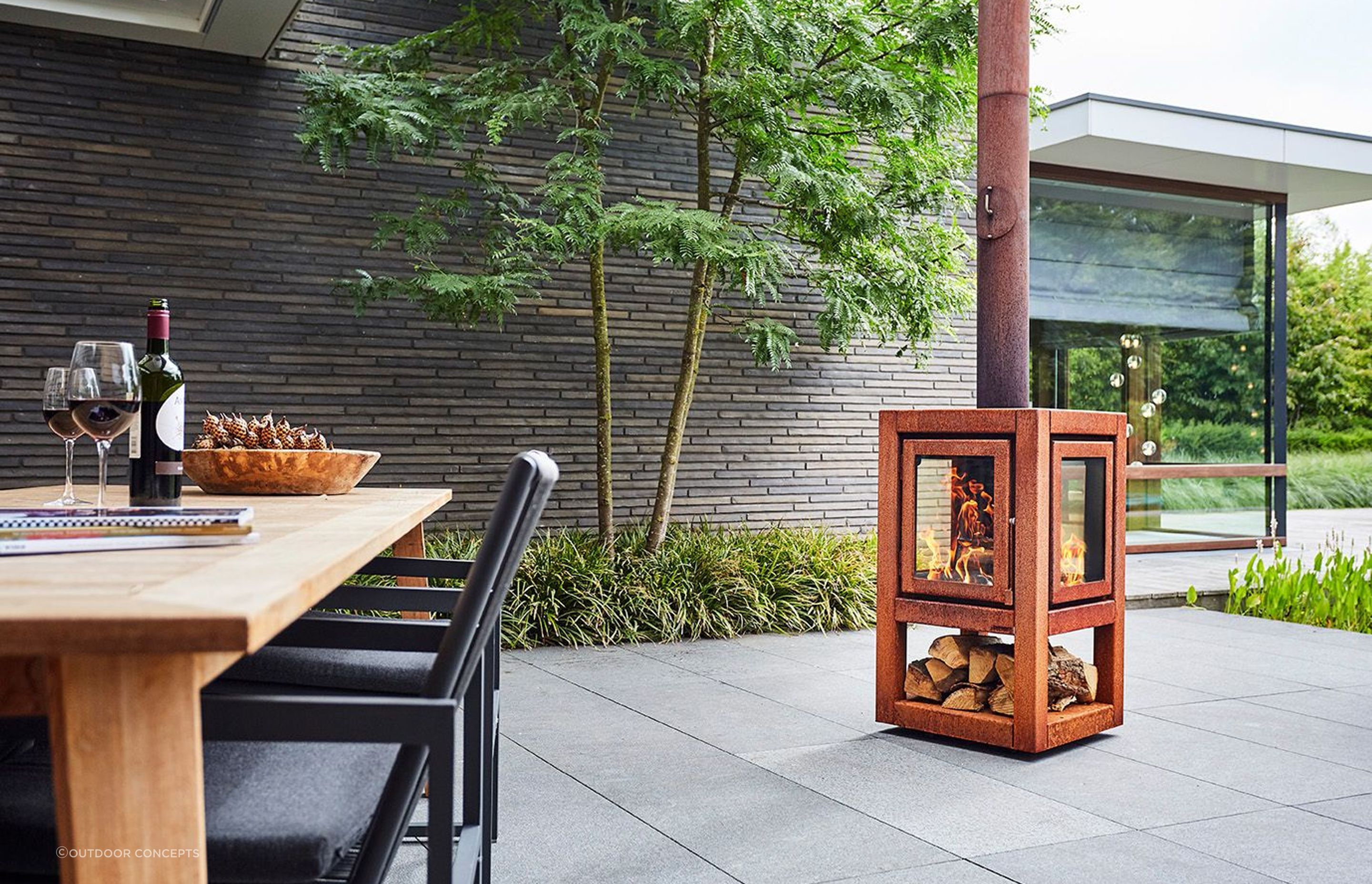 Even a small wood fire like this Quaruba fireplace can provide cost-effective heat outdoors. 