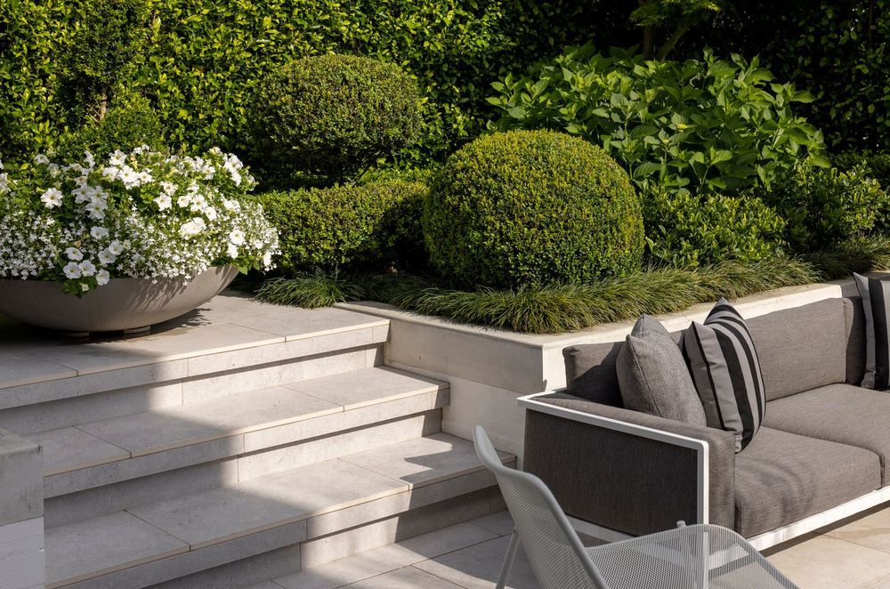White flowers bloom in a low bowl planter.