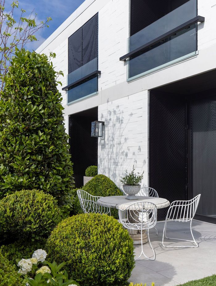 An intimate courtyard is hidden from the road by an abundance of greenery, yet still offers sweeping views of Remuera.