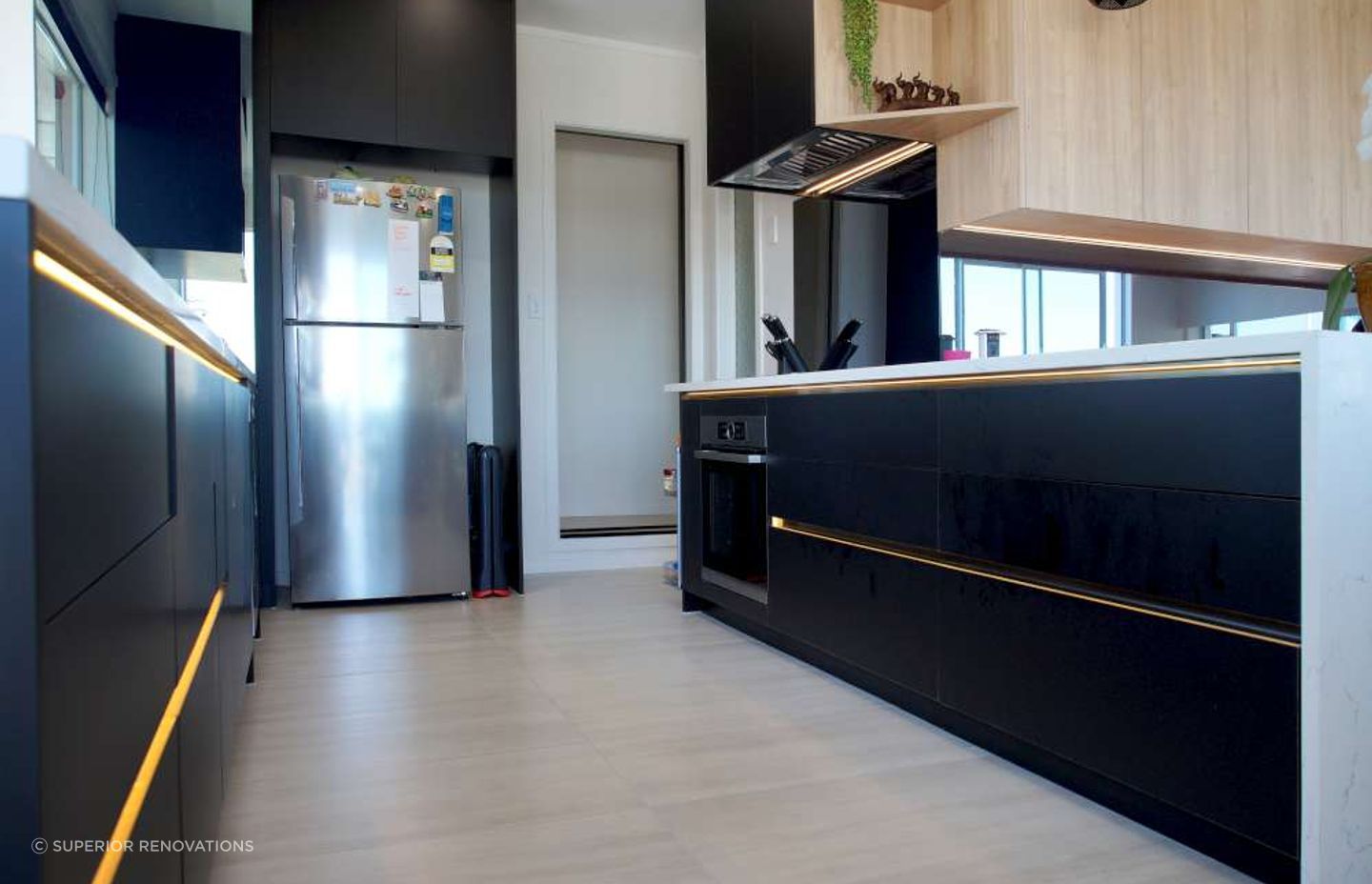 Kitchen renovation in West Auckland Massey - Our client in Massey wanted black cabinets against white to give a luxurious feel to his kitchen. LED lights were also installed under the cabinet handles to add to the glamour of the kitchen.
