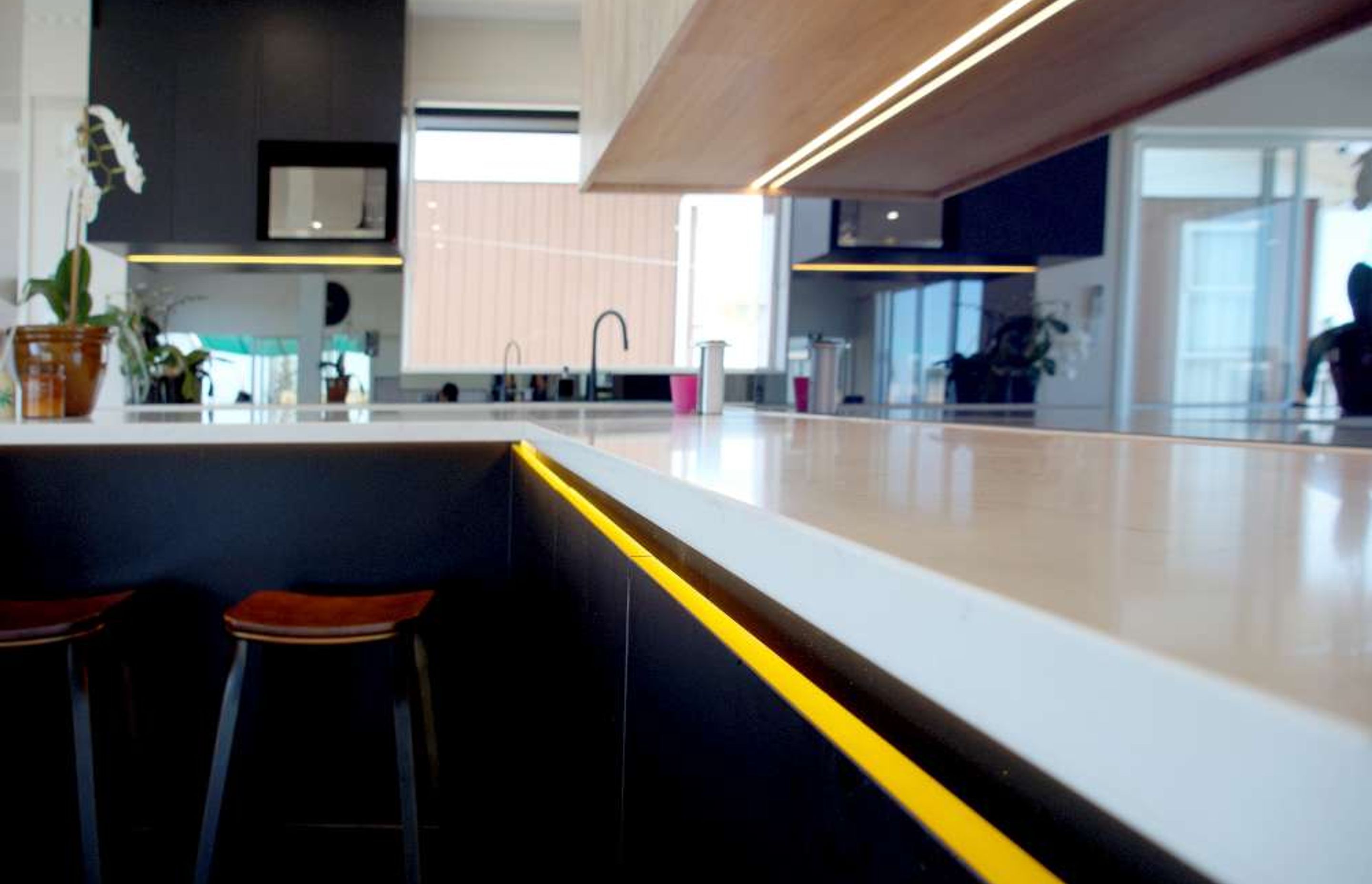 Yellow LED lights installed below the countertop which provides a great contrast to black cabinets