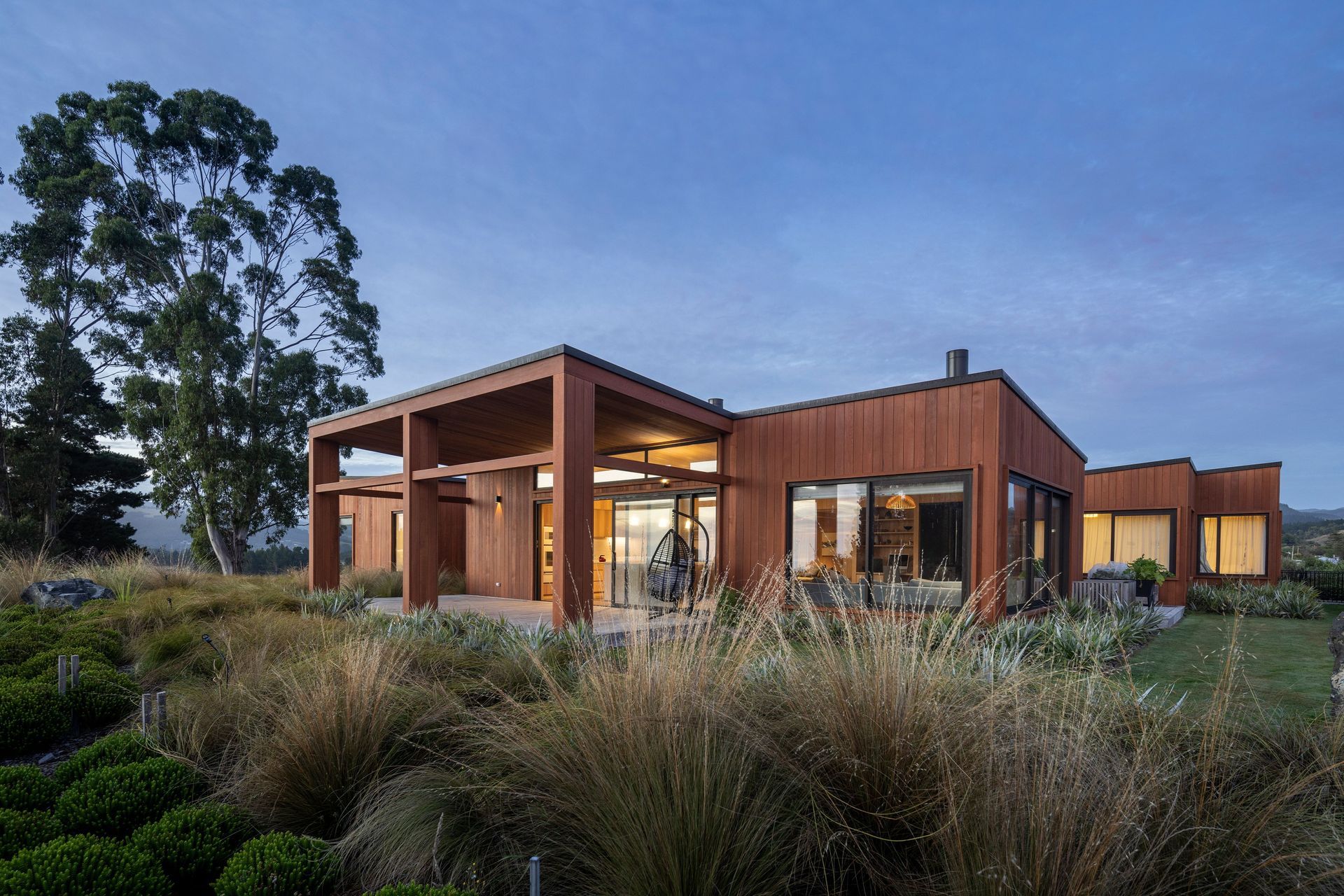 The east side of Coastal Retreat, anchored by a large sheltered deck that extends from the main living area and captures the morning sun. | Photographer: Graham Warman
