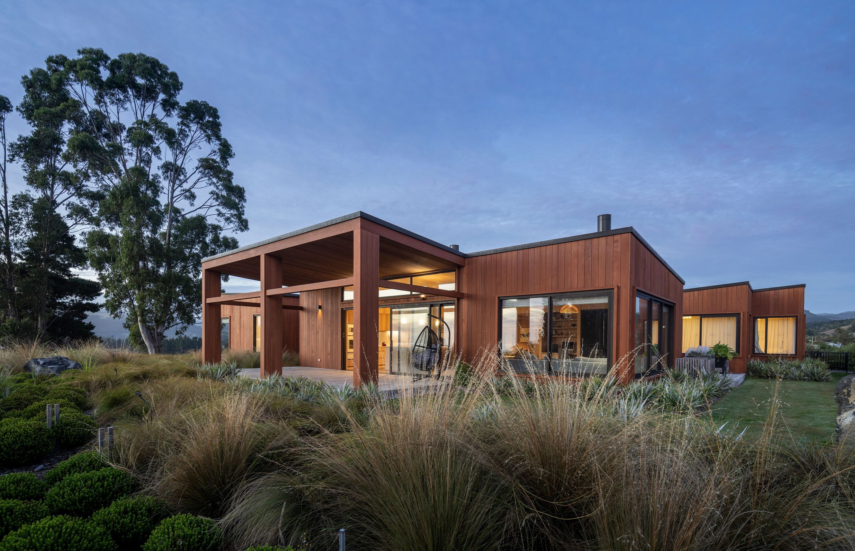 The east side of Coastal Retreat, anchored by a large sheltered deck that extends from the main living area and captures the morning sun. | Photographer: Graham Warman