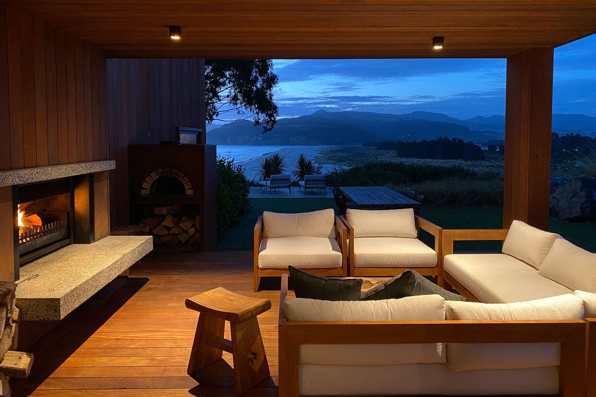 The south side’s outdoor living area, looking out across Warrington Beach and Blueskin Bay. | Photographer: Ruth Whitaker