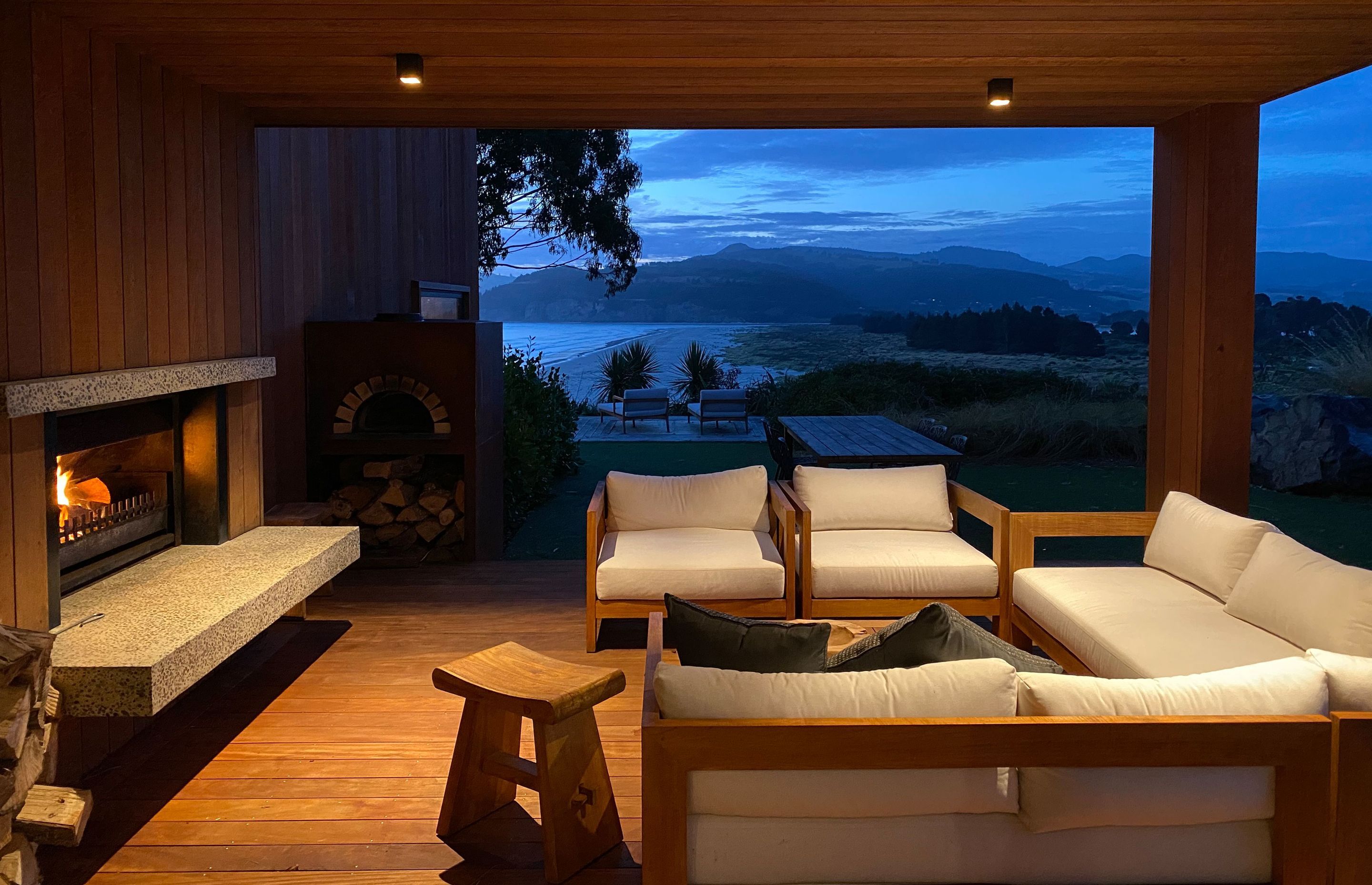 The south side’s outdoor living area, looking out across Warrington Beach and Blueskin Bay. | Photographer: Ruth Whitaker