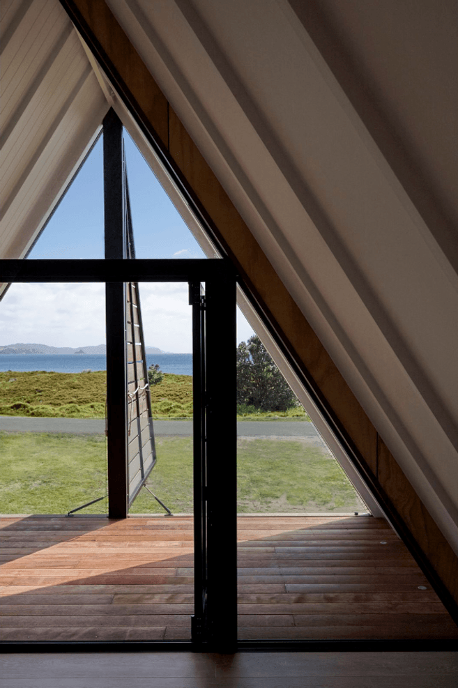 Upstairs, the architect's favourite spot in the house is the covered deck in the triangular master bedroom space, with its dormer shutters that open to reveal the view. A glass balustrade is almost invisible.