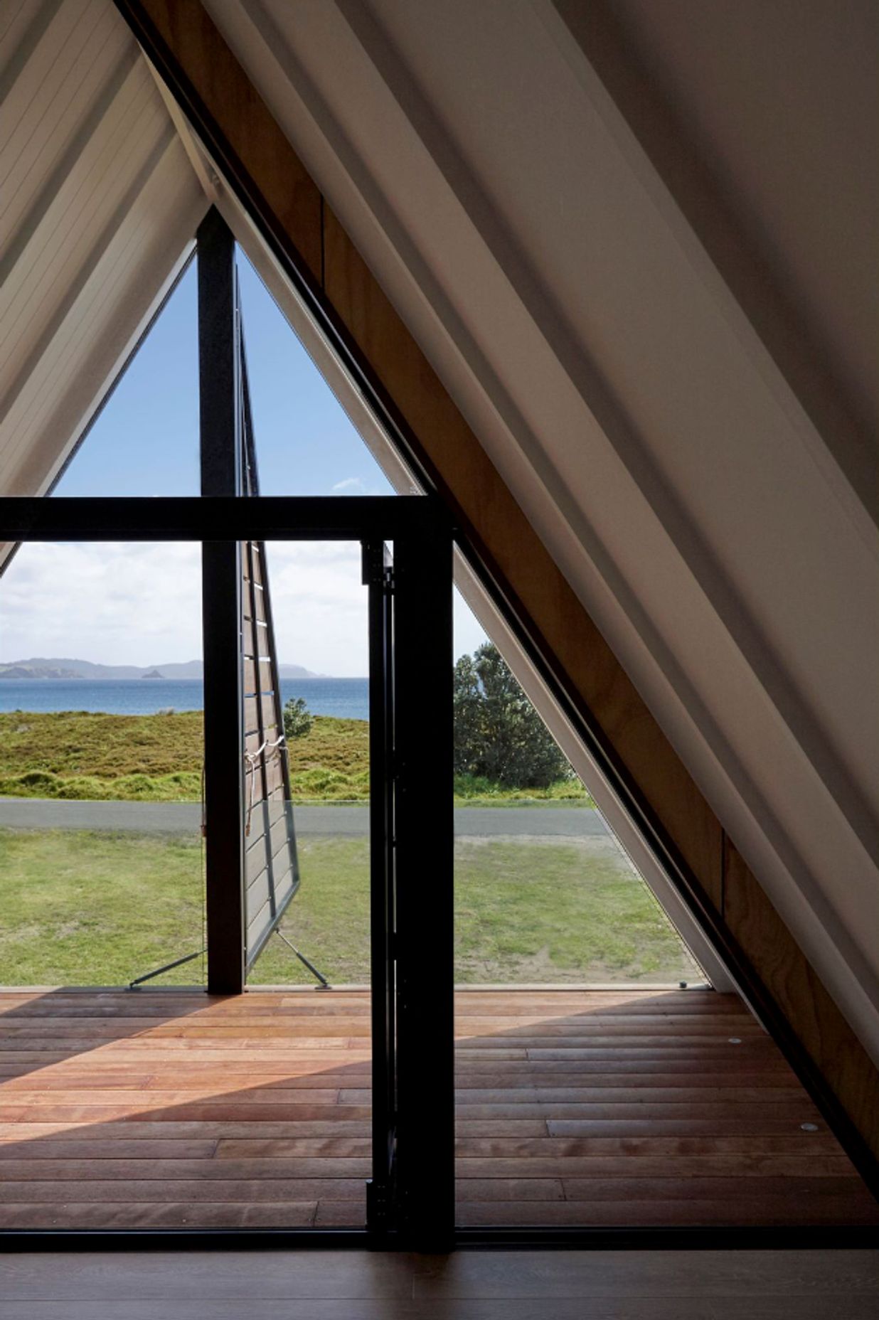 Upstairs, the architect's favourite spot in the house is the covered deck in the triangular master bedroom space, with its dormer shutters that open to reveal the view. A glass balustrade is almost invisible.