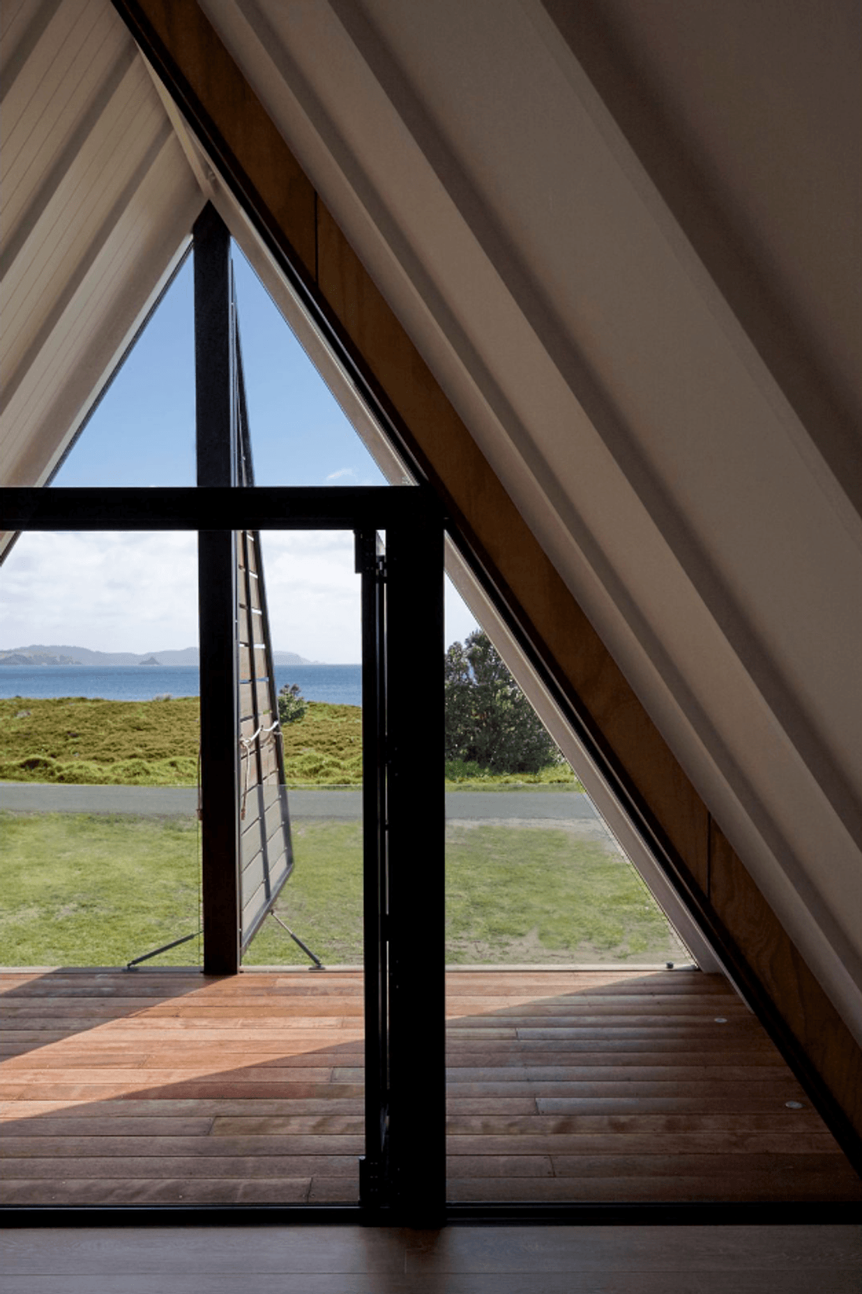 Upstairs, the architect's favourite spot in the house is the covered deck in the triangular master bedroom space, with its dormer shutters that open to reveal the view. A glass balustrade is almost invisible.
