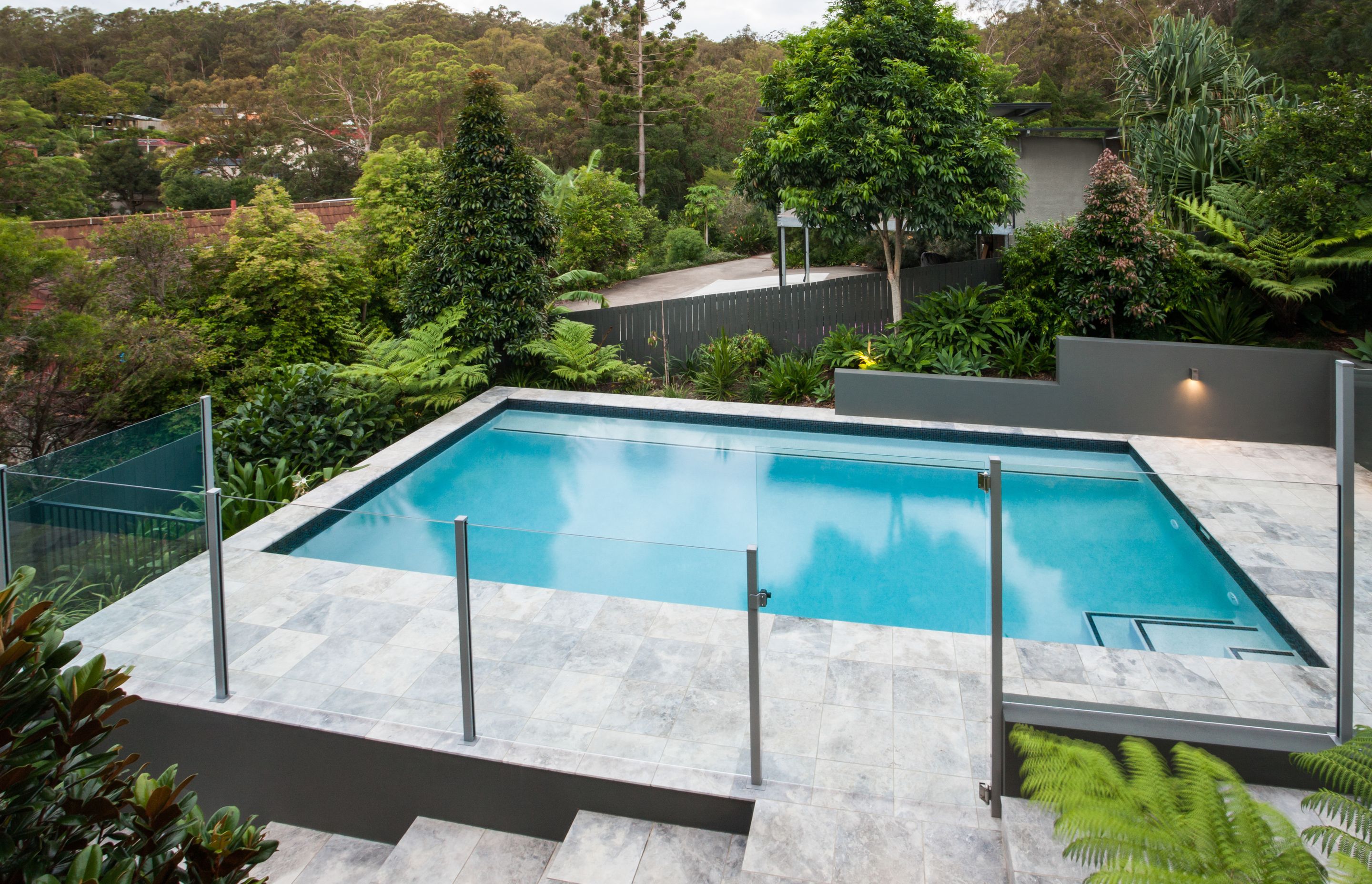 A semi-framed glass pool fence provides stability and safety.