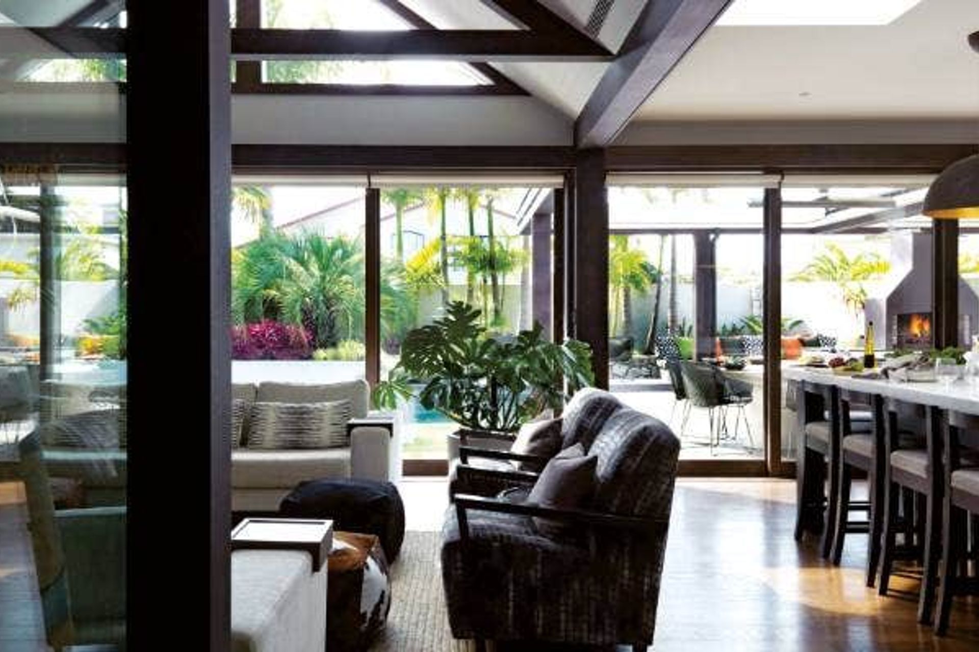 The kitchen/family room area looks out to a resort-like garden designed by Robin Shafer from Shafer Design; the Flare outdoor fire doubles as a pizza oven and also has a pulley system, so meat can be smoked up the chimney.