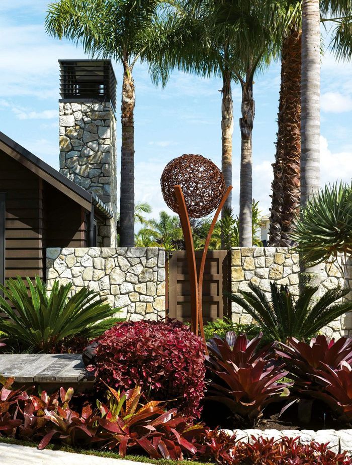 A boardwalk adds to the resort-like feel of the entrance, with planting that includes cycads, iresine and bromeliads; the sculpture is by Wire Art – the couple spotted a similar one at a Wānaka vineyard.