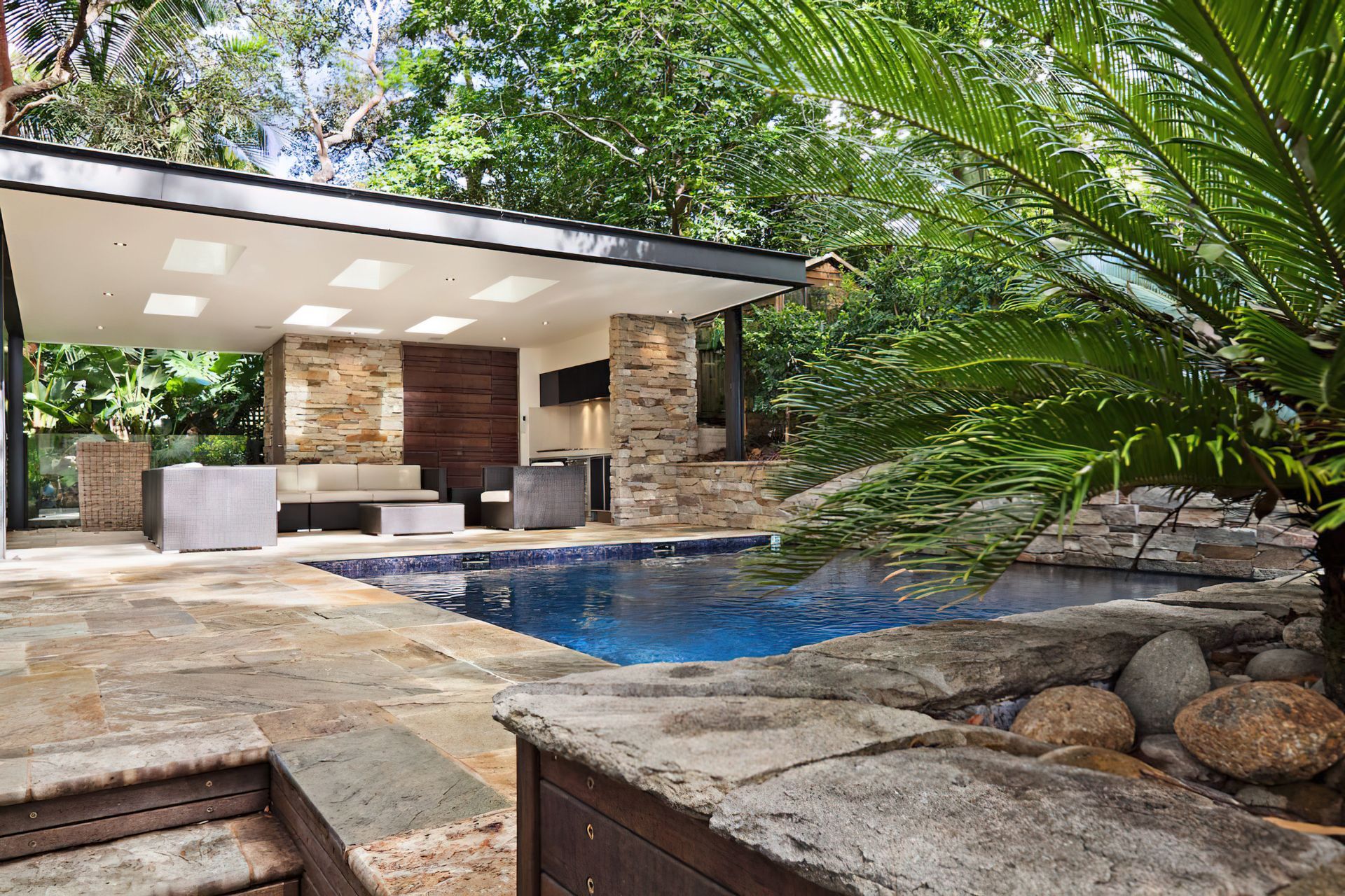 A stone wall can transform your pool into a lush natural feeling oasis. Featured project: Lindfield.