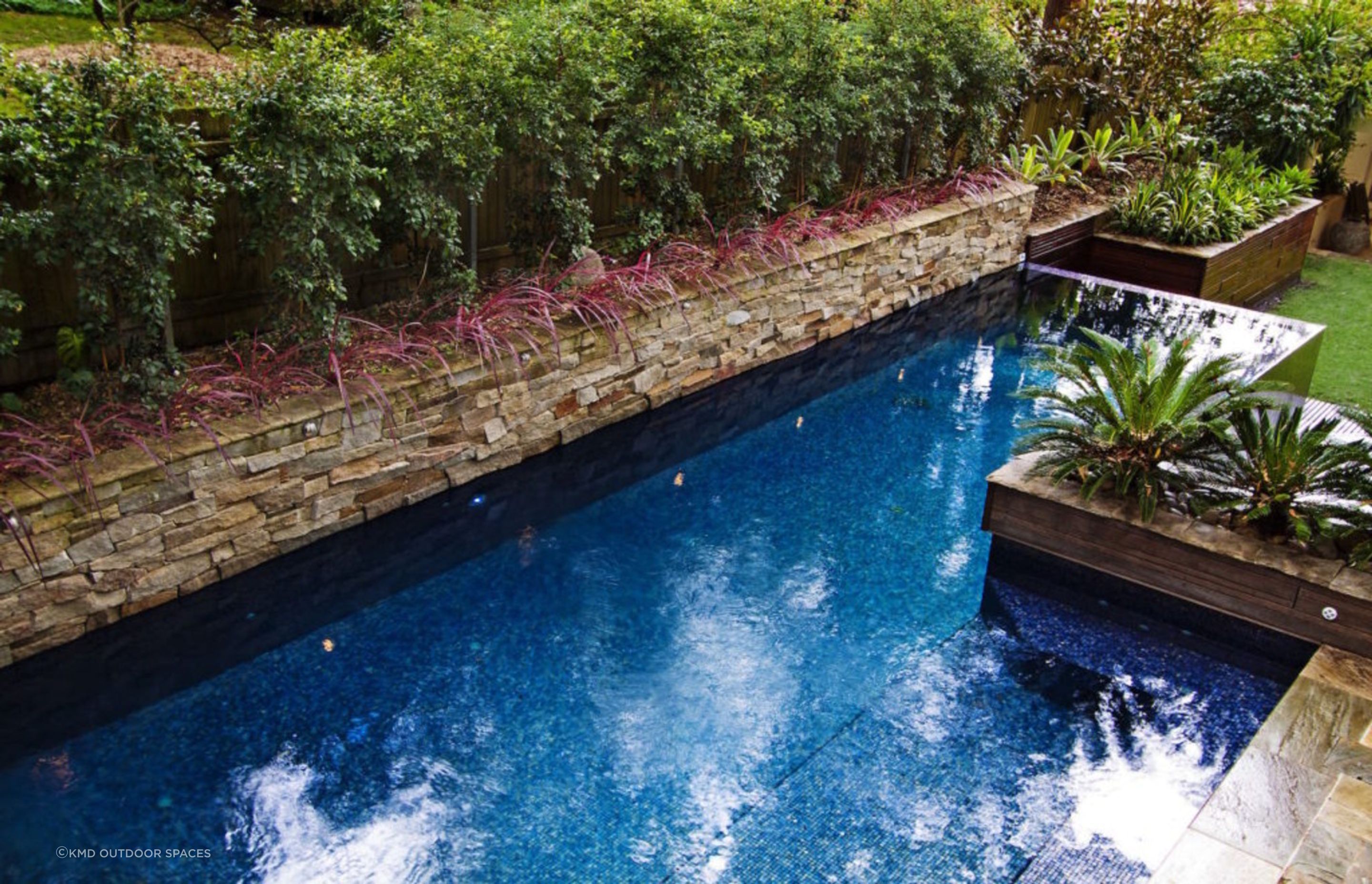A stone wall can transform your pool into a lush natural feeling oasis. Featured project: Lindfield.