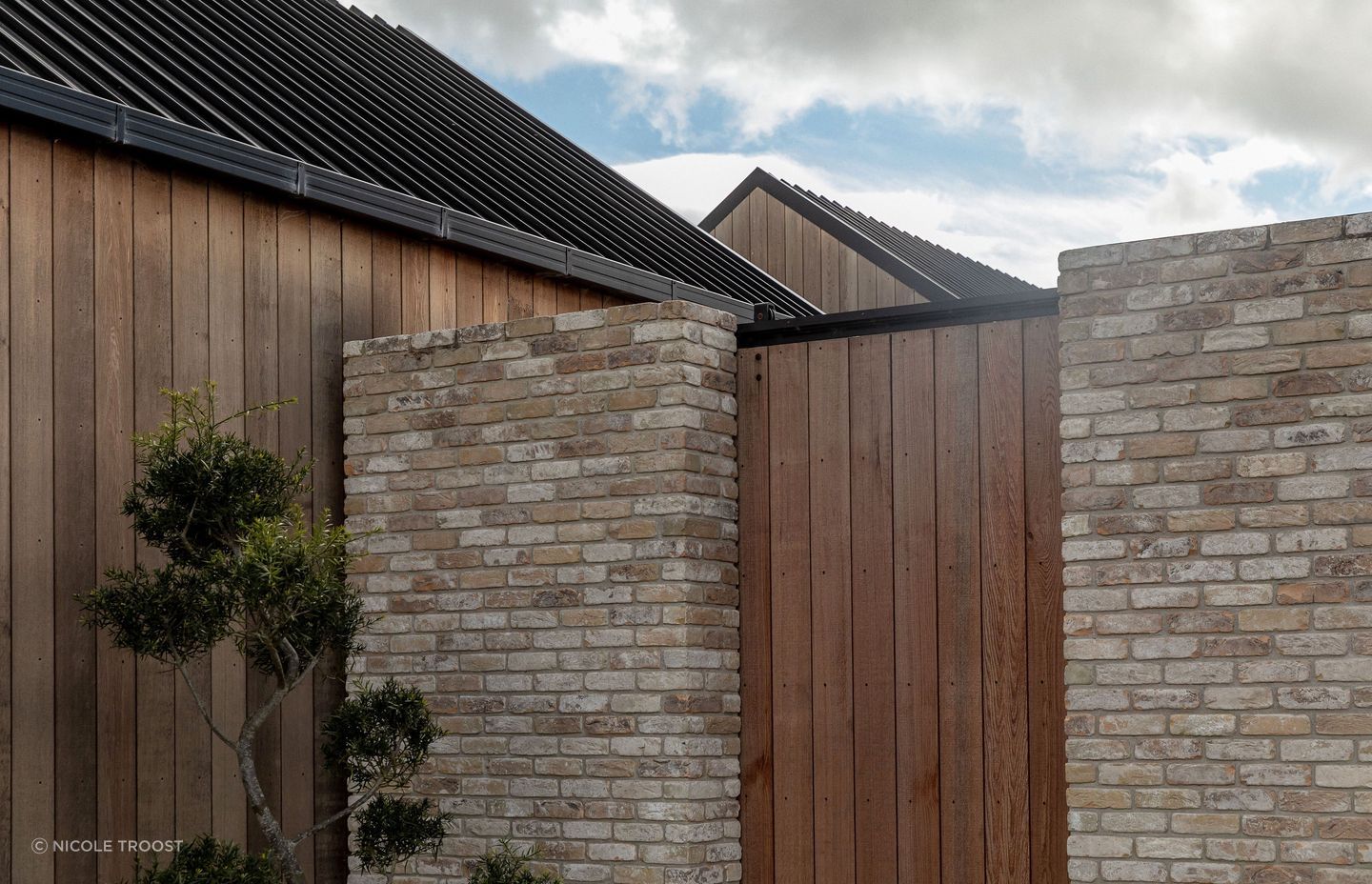 The juxtaposition of cedar, black steel and pale brick forms a rich exterior materiality.