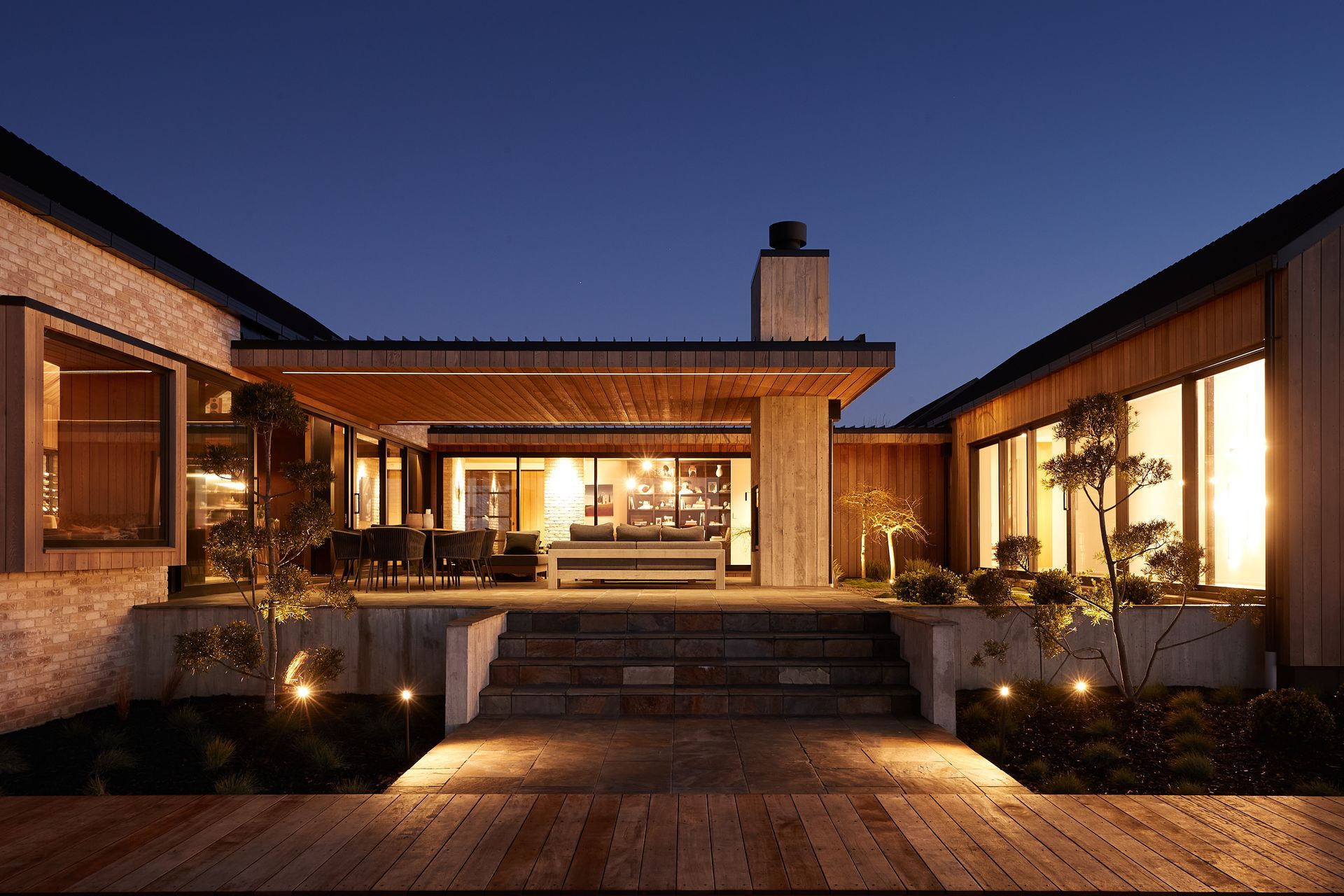 Photo credit: Mark Hamilton. The outdoor internal courtyard with built-in outdoor fireplace features slate paving and Zen garden-like plantings.