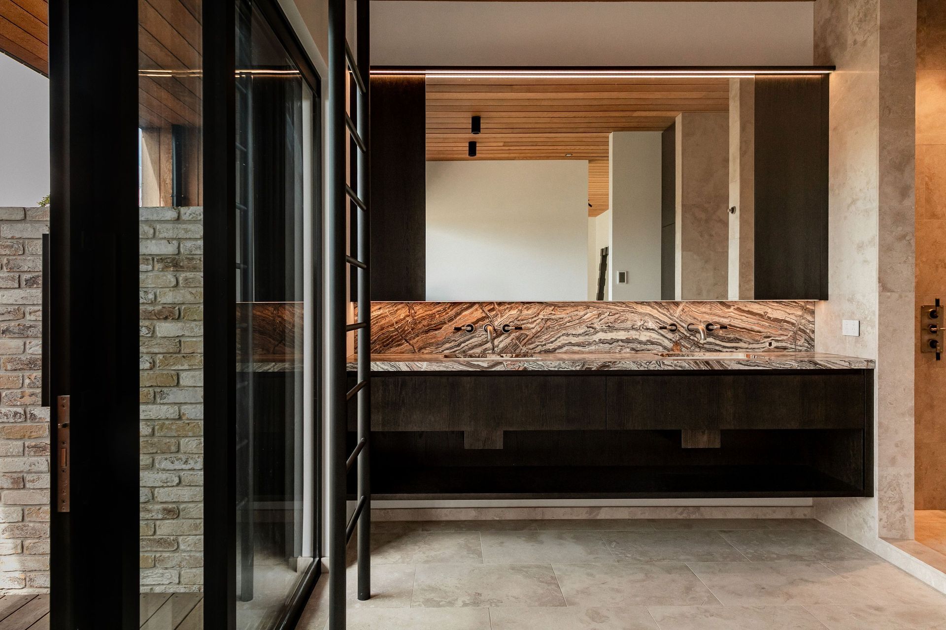 The master en suite features stone double basins and a walk-in shower room to the right.