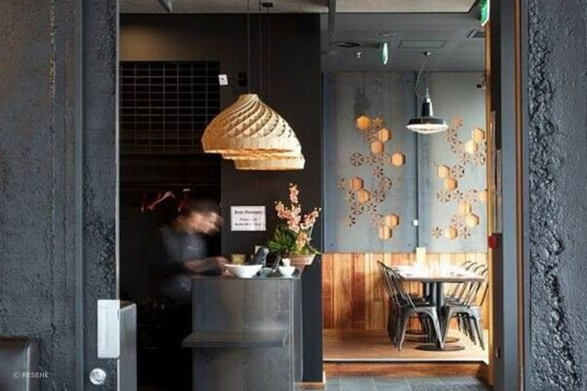 Spice Paragon Restaurant in Christchurch features Muros Grey Roughcast Concrete wall panels installed vertically and painted in Resene All Black. Design by Crafted.