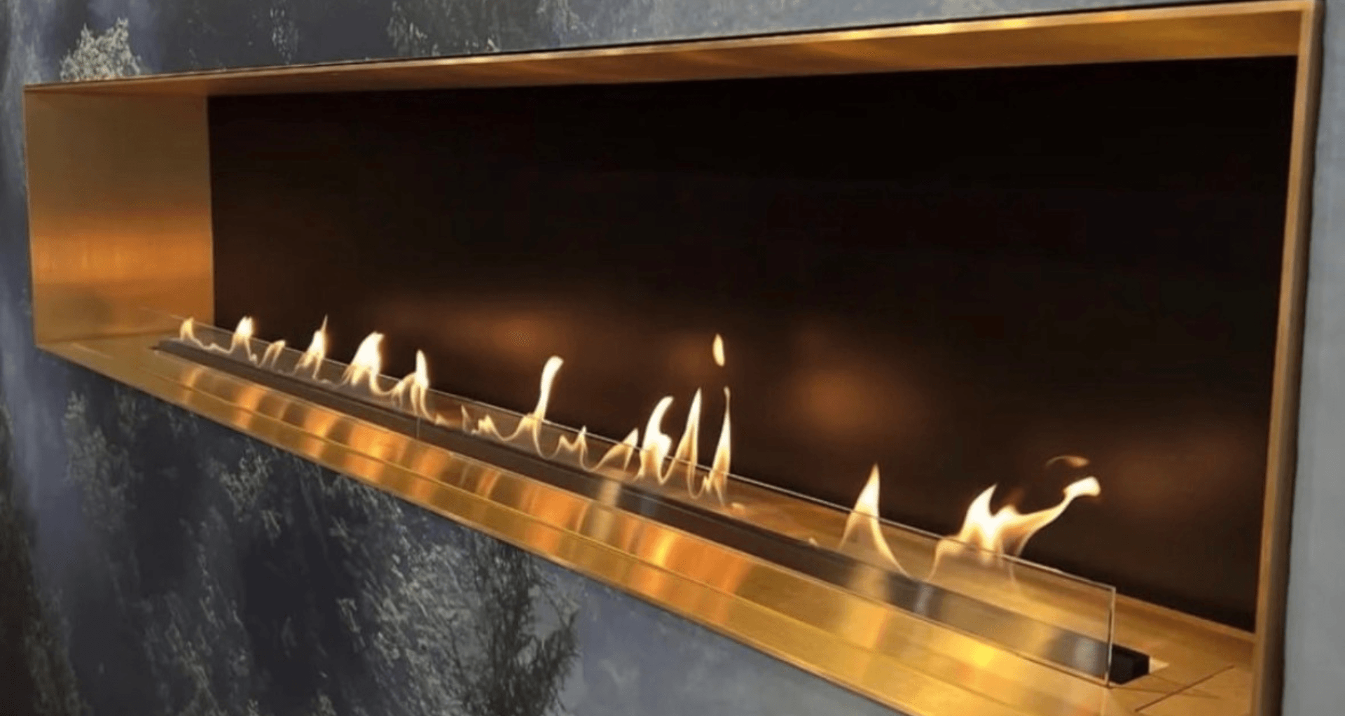 Decoflame BEV Net Zero linear fireplace in custom brass with glass fender—real flame, electric-connected, no flue—ideal for Australia & New Zealand.