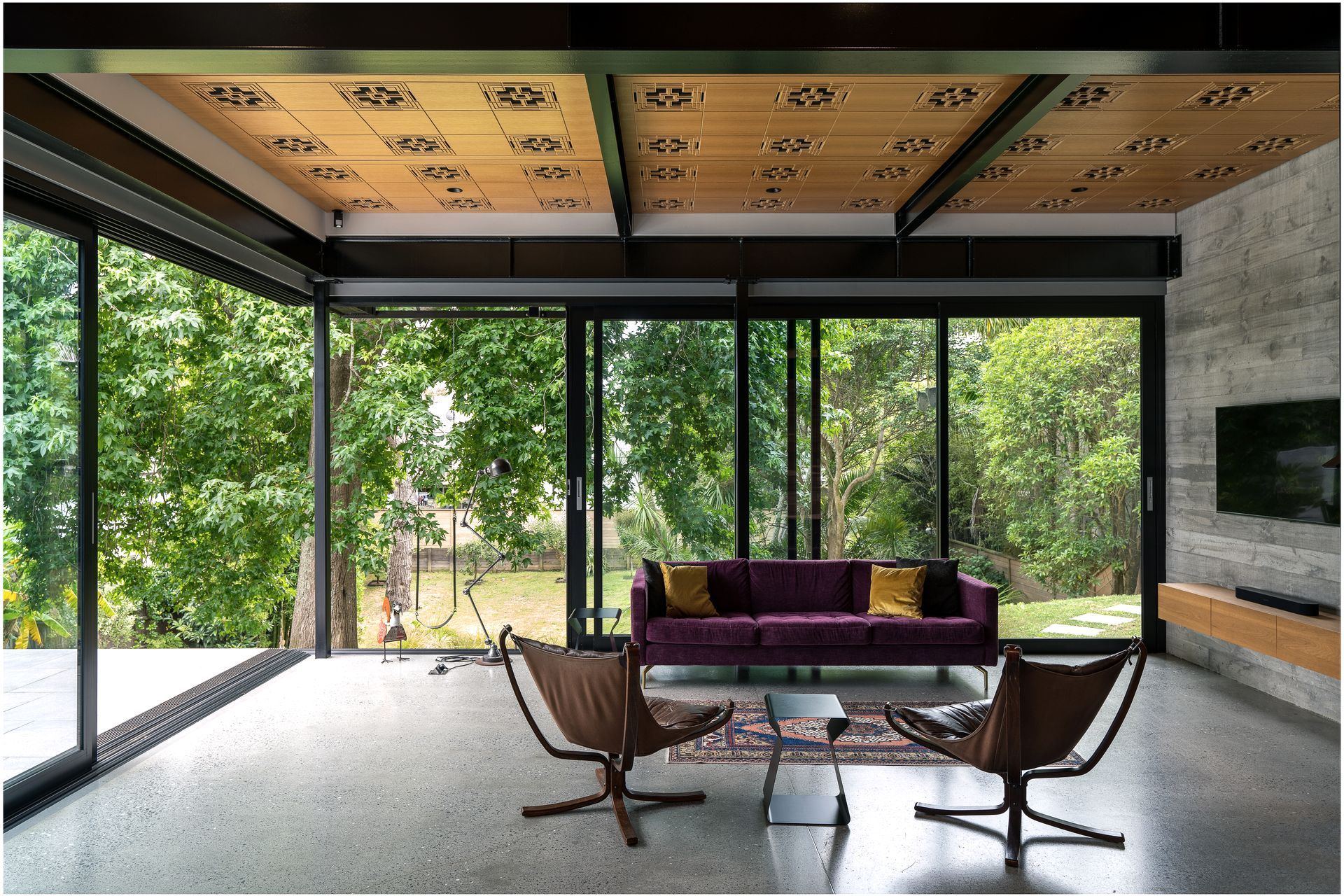 The custom routed acoustic ceiling pattern was inspired by Frank Lloyd Wright. The homeowners found the two Falcon chairs online. “That classic Swedish modern style fits perfectly within those Case Study Houses that were one of the design precedents for this project. The purple couch we had made by BoConcept because we just wanted a splash of colour. Before becoming an architect, I did a degree in underwater archaeology and excavated boats. One of the projects I worked on was in Turkey, where I bought this rug for my then-girlfriend who's now my wife.”