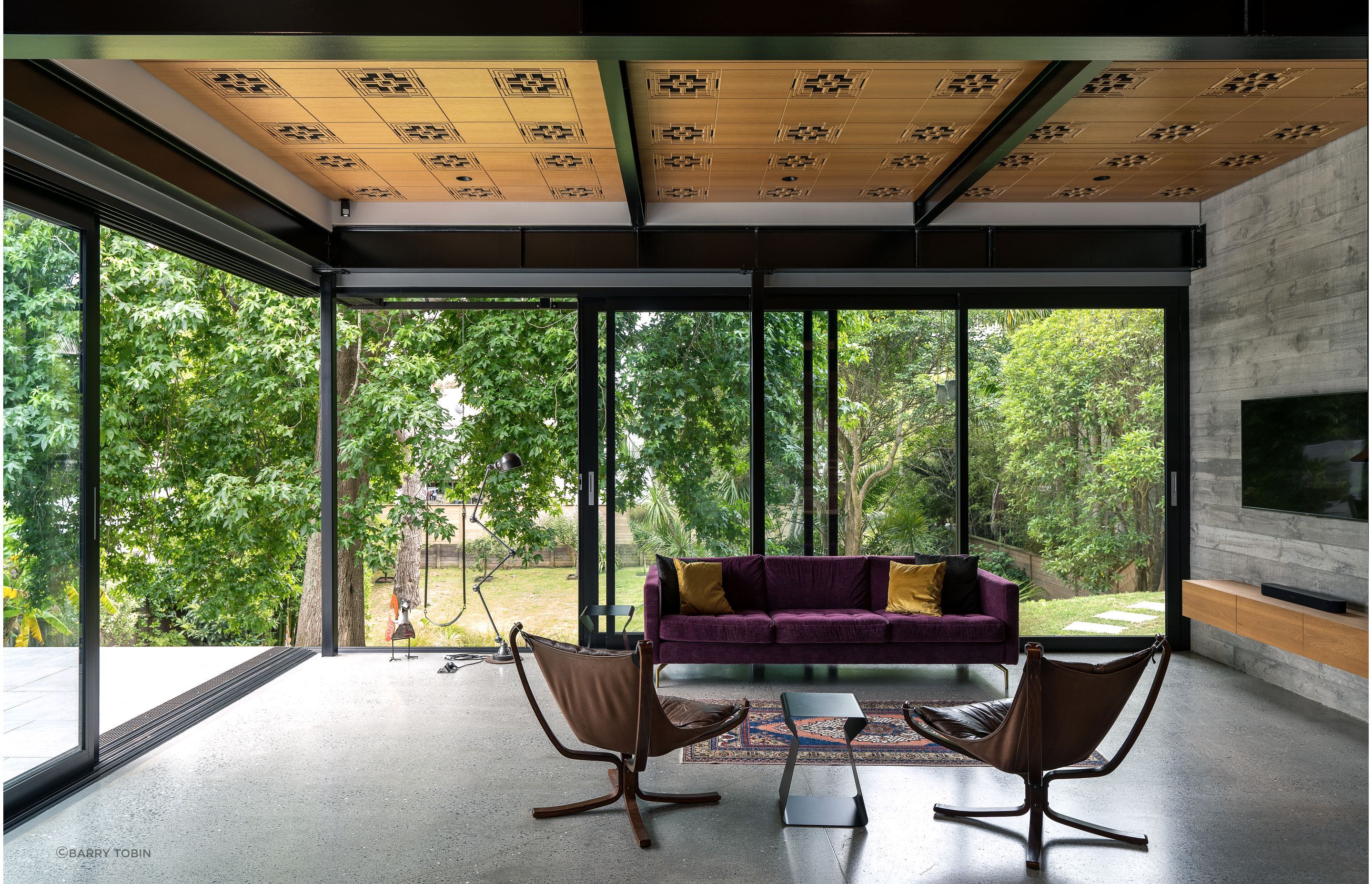 The custom routed acoustic ceiling pattern was inspired by Frank Lloyd Wright. The homeowners found the two Falcon chairs online. “That classic Swedish modern style fits perfectly within those Case Study Houses that were one of the design precedents for this project. The purple couch we had made by BoConcept because we just wanted a splash of colour. Before becoming an architect, I did a degree in underwater archaeology and excavated boats. One of the projects I worked on was in Turkey, where I bought this rug for my then-girlfriend who's now my wife.”
