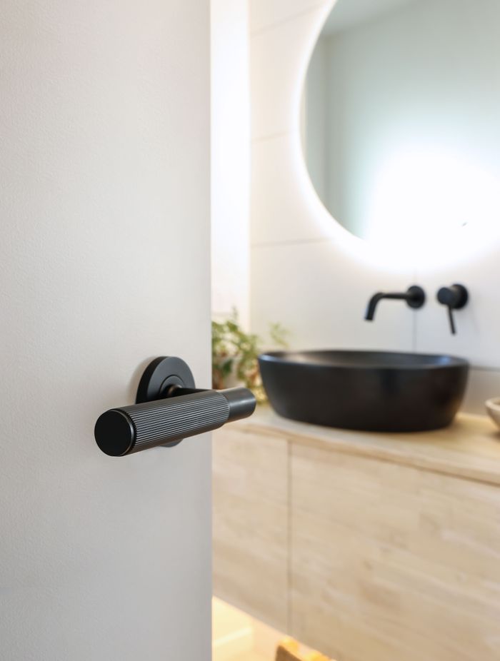 The NIDO linear knurl door handle in black.