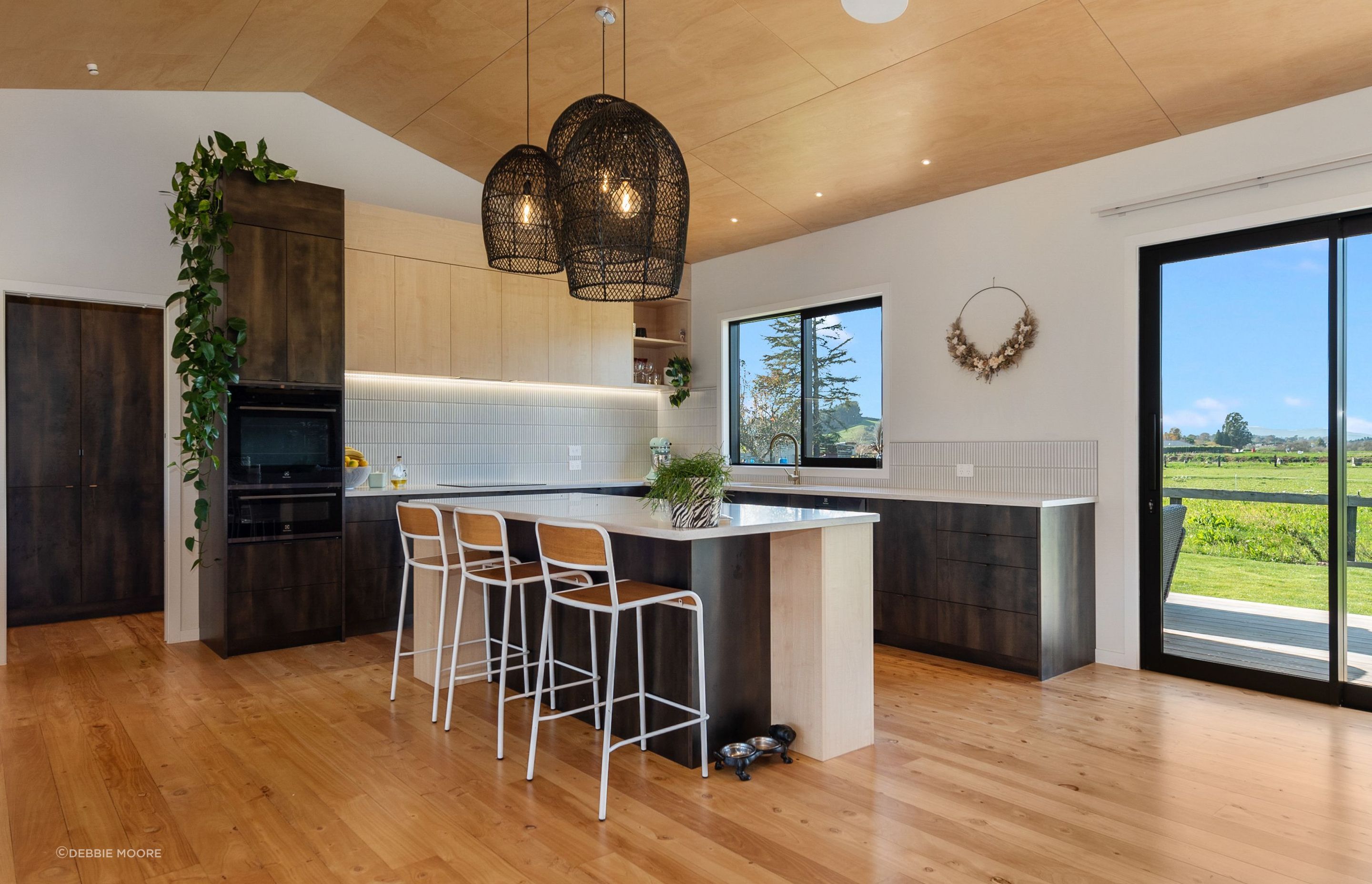 The raked ceiling in the kitchen and living area is finished with ply with negative detailing.