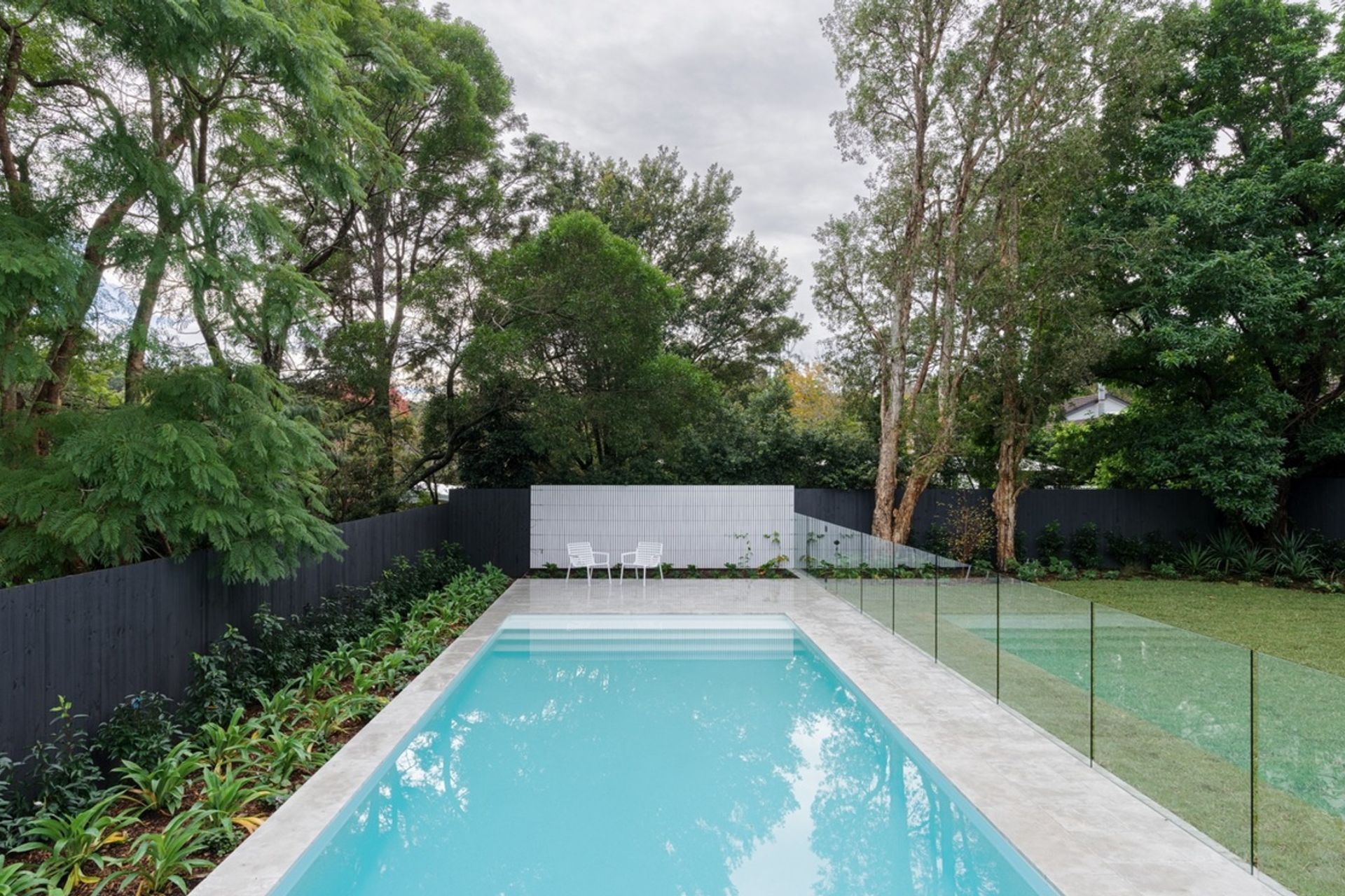 Glass fences can provide a stylish contrast to traditional wood fencing panels. Featured project: Warrawee Residence.