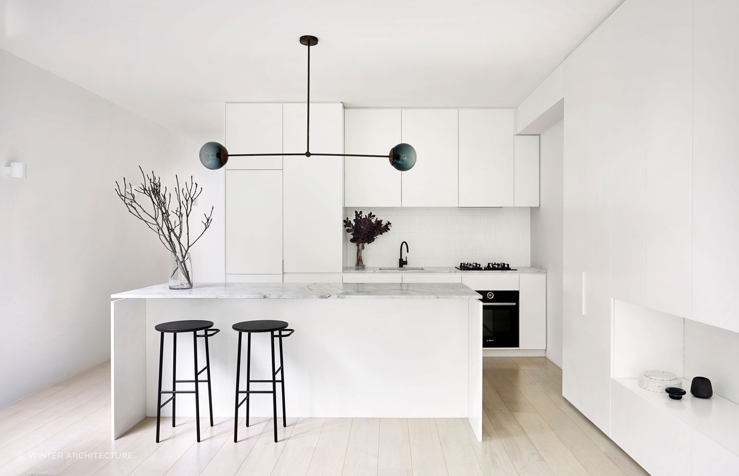 The kitchen embodies a sleek and minimalist aesthetic. Photography by Tatjana Plitt.