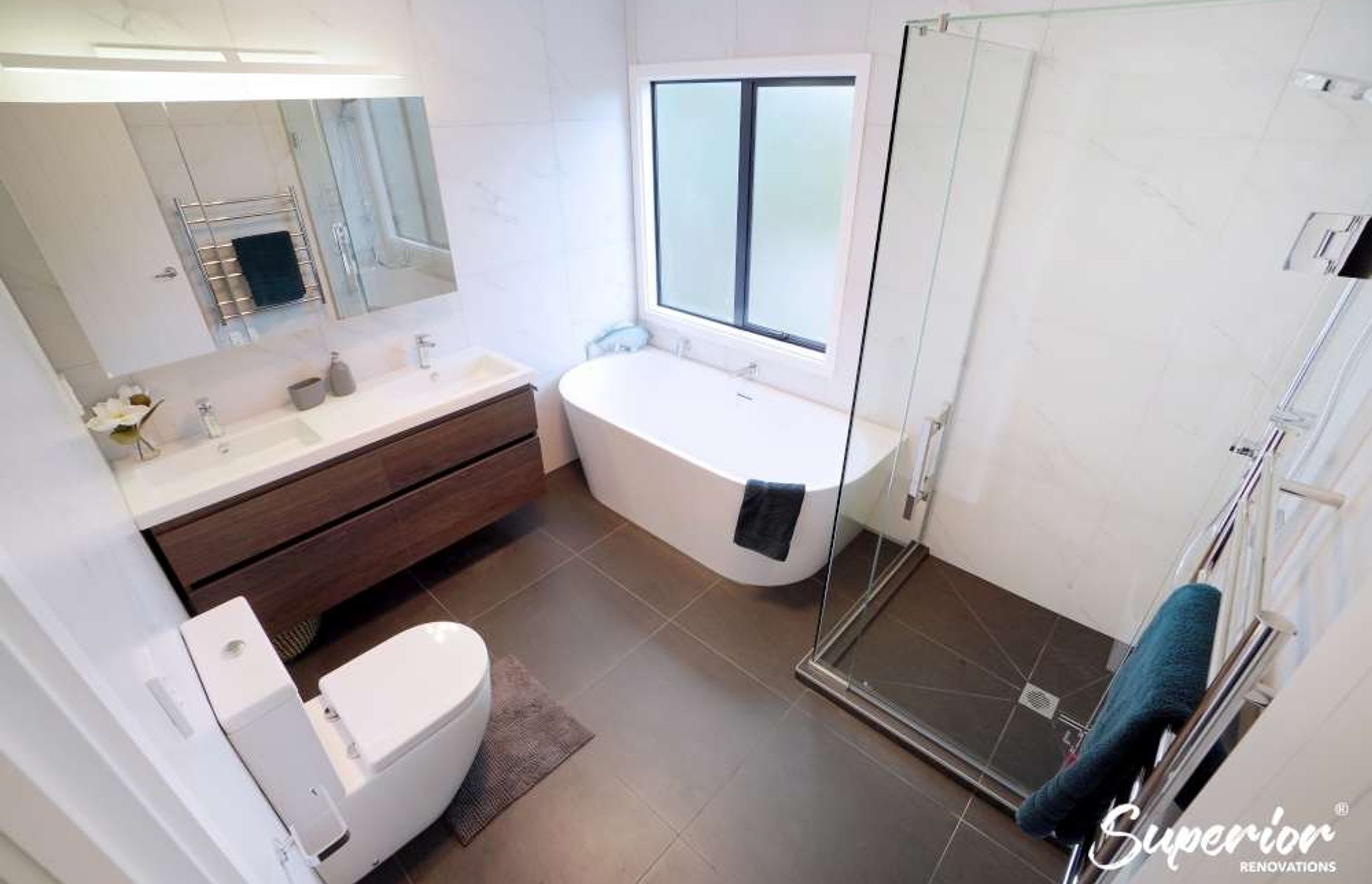Dark brown 600 by 600 tiles were installed on the floors whereas white 600 by 600 tiles were installed on the walls to make the bathroom look spacious as well as create some drama