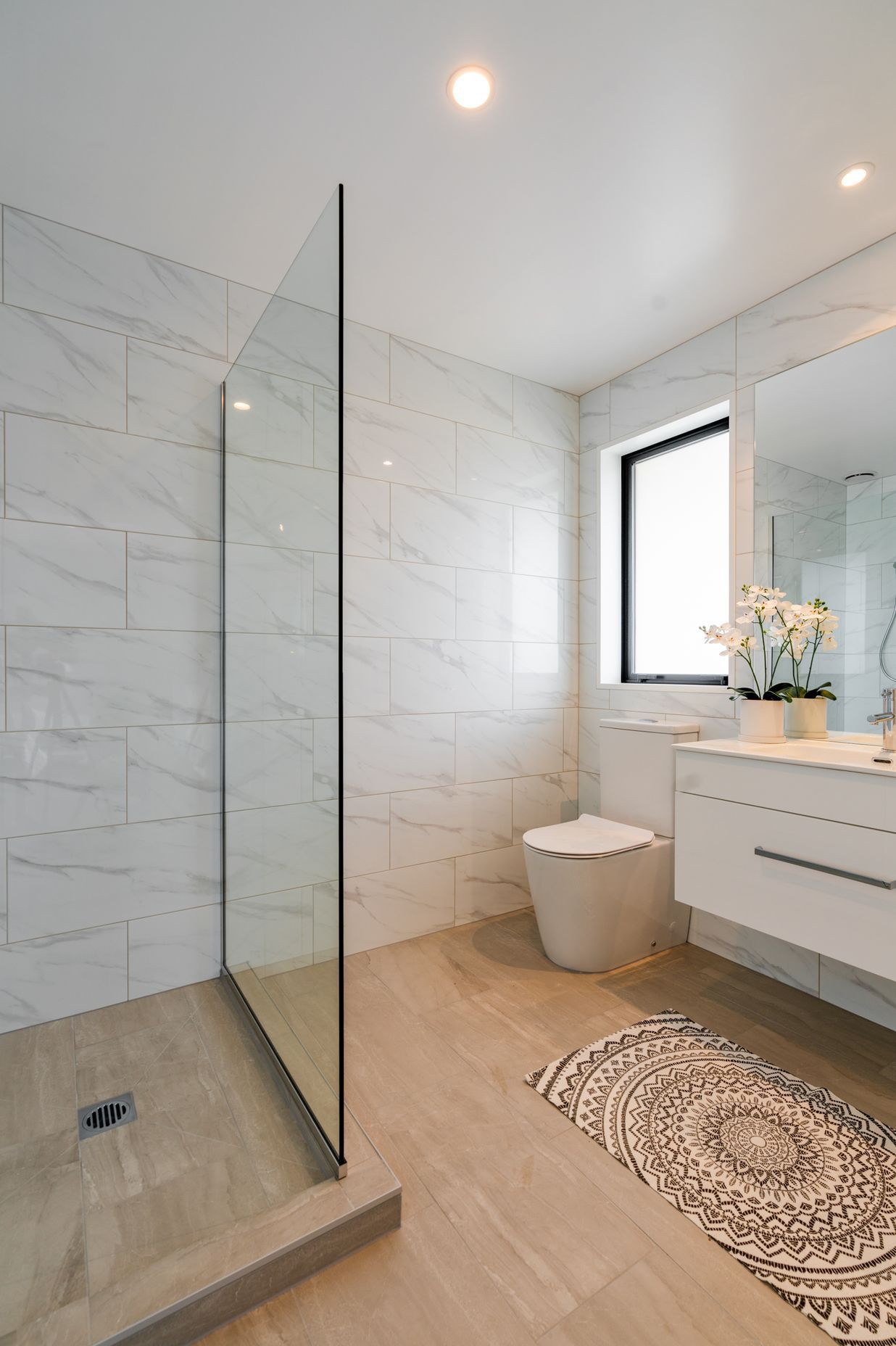 The client decided on a tiled shower after the foundation was poured in this ensuite bathroom, so Bird Built installed a shower hob.