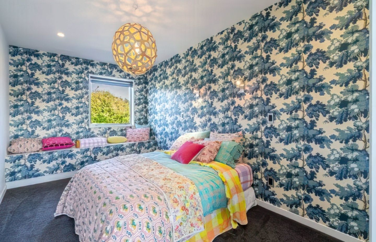 The bedroom is as colourful as the rest of the home, with pinks, blues and oranges completing the look.